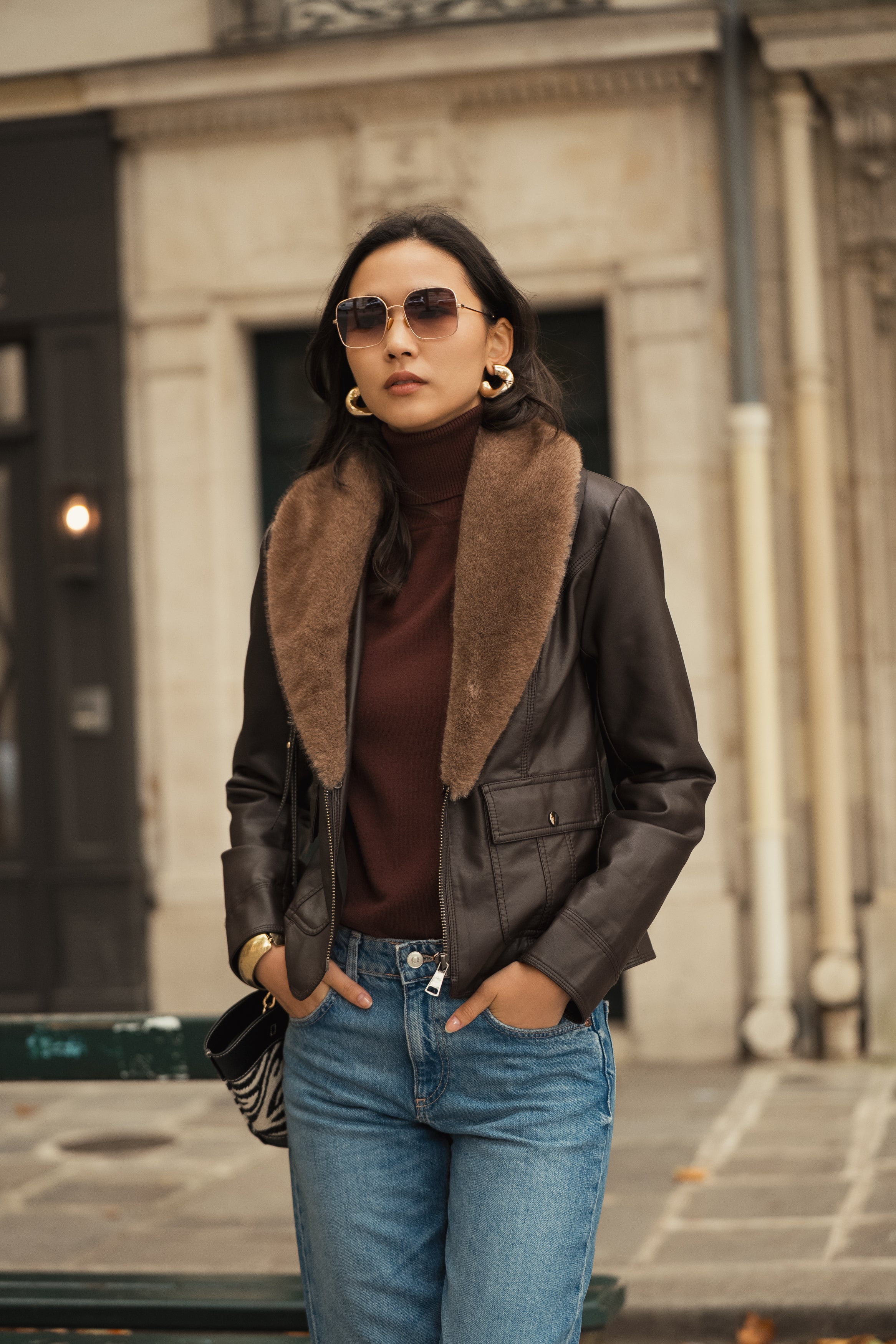 Femme portant veste en simili cuir marron avec grand col en fausse fourrure taupe amovible Escandelle – look chic parisien automne
#couleur_choco