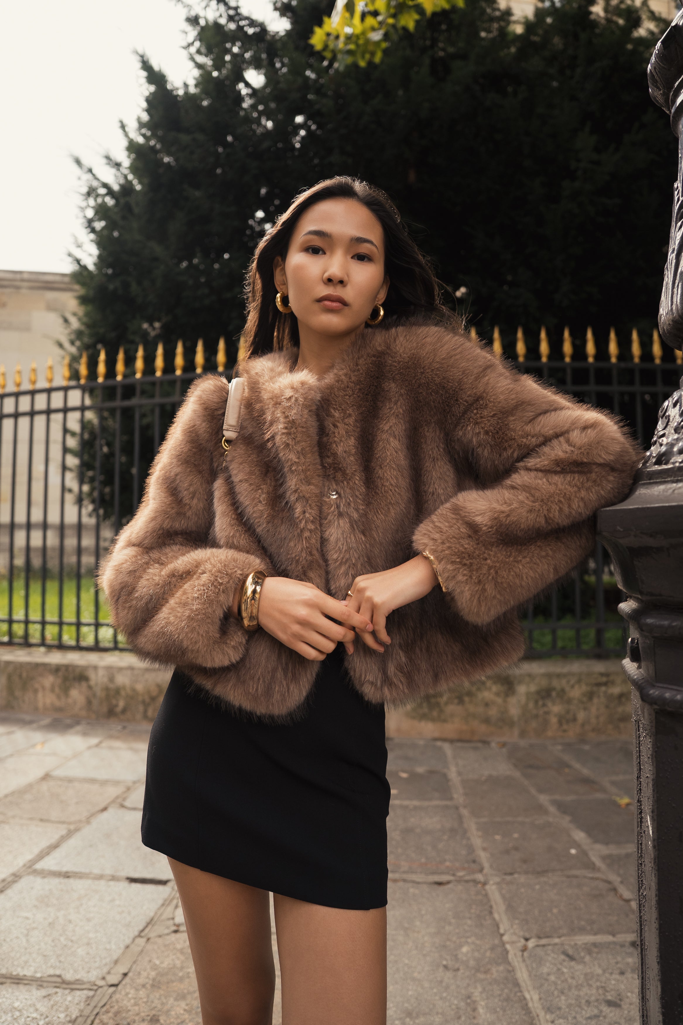 Manteau court en fausse fourrure femme Escandelle Paris, coloris brun, col rond, fermeture à pressions dissimulées, coupe élégante et poils longs doux.
#couleur_taupe