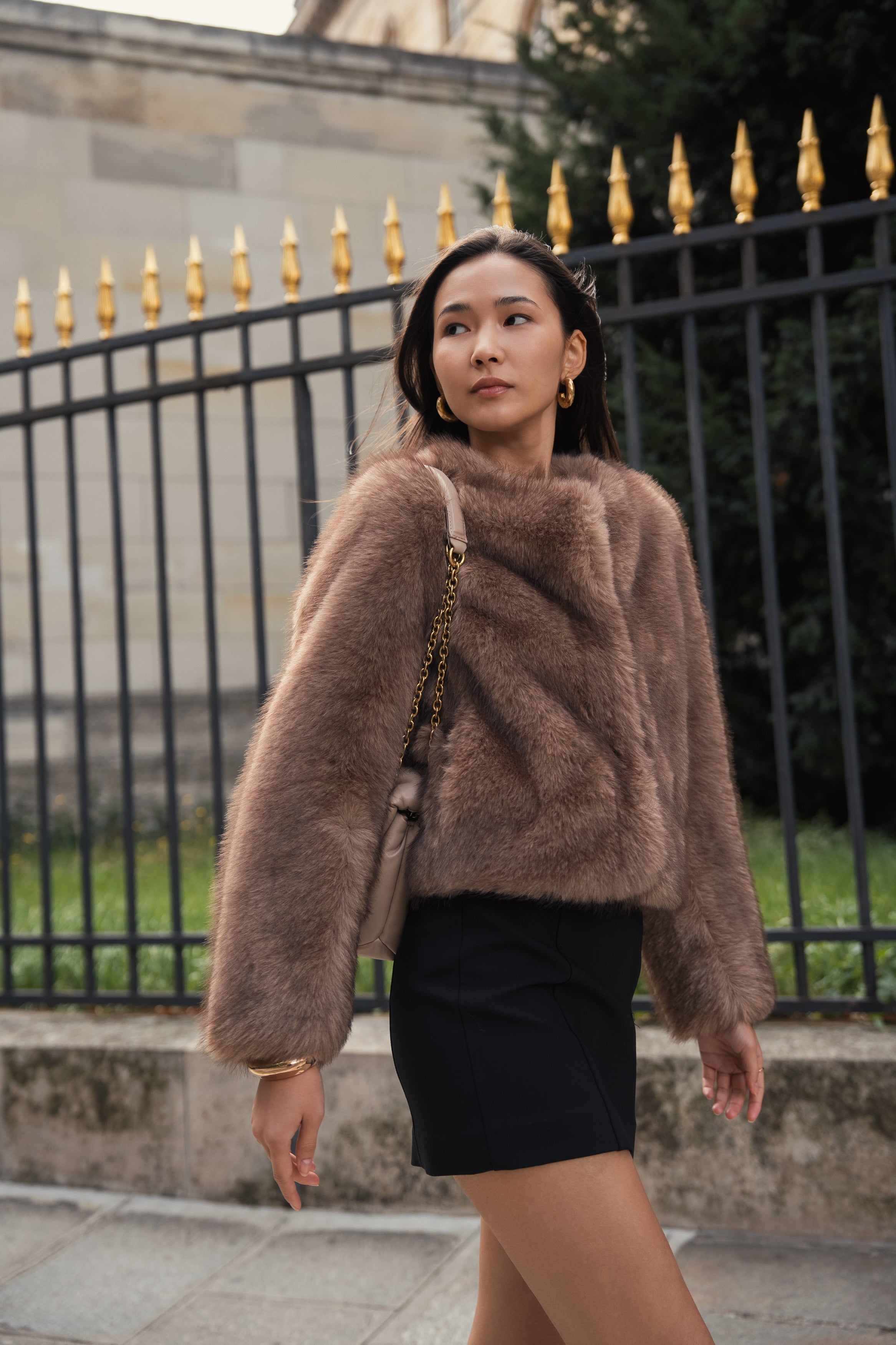 Manteau court en fausse fourrure femme Escandelle Paris, coloris brun, col rond, fermeture à pressions dissimulées, coupe élégante et poils longs doux.
#couleur_taupe