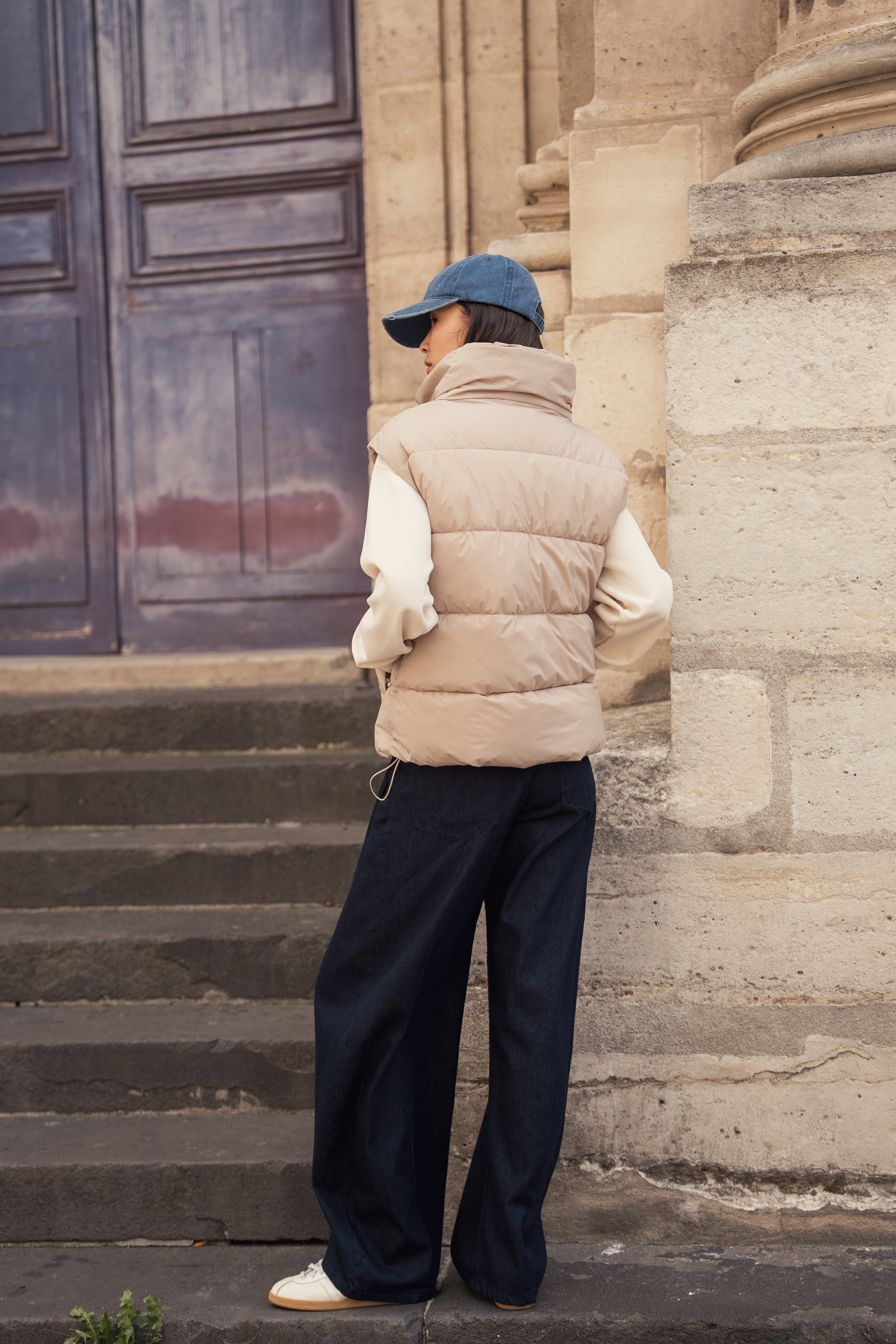 Femme portant une doudoune sans manches beige modèle Helene d'Escandelle Paris, look décontracté et chic en extérieur
#couleur_beige