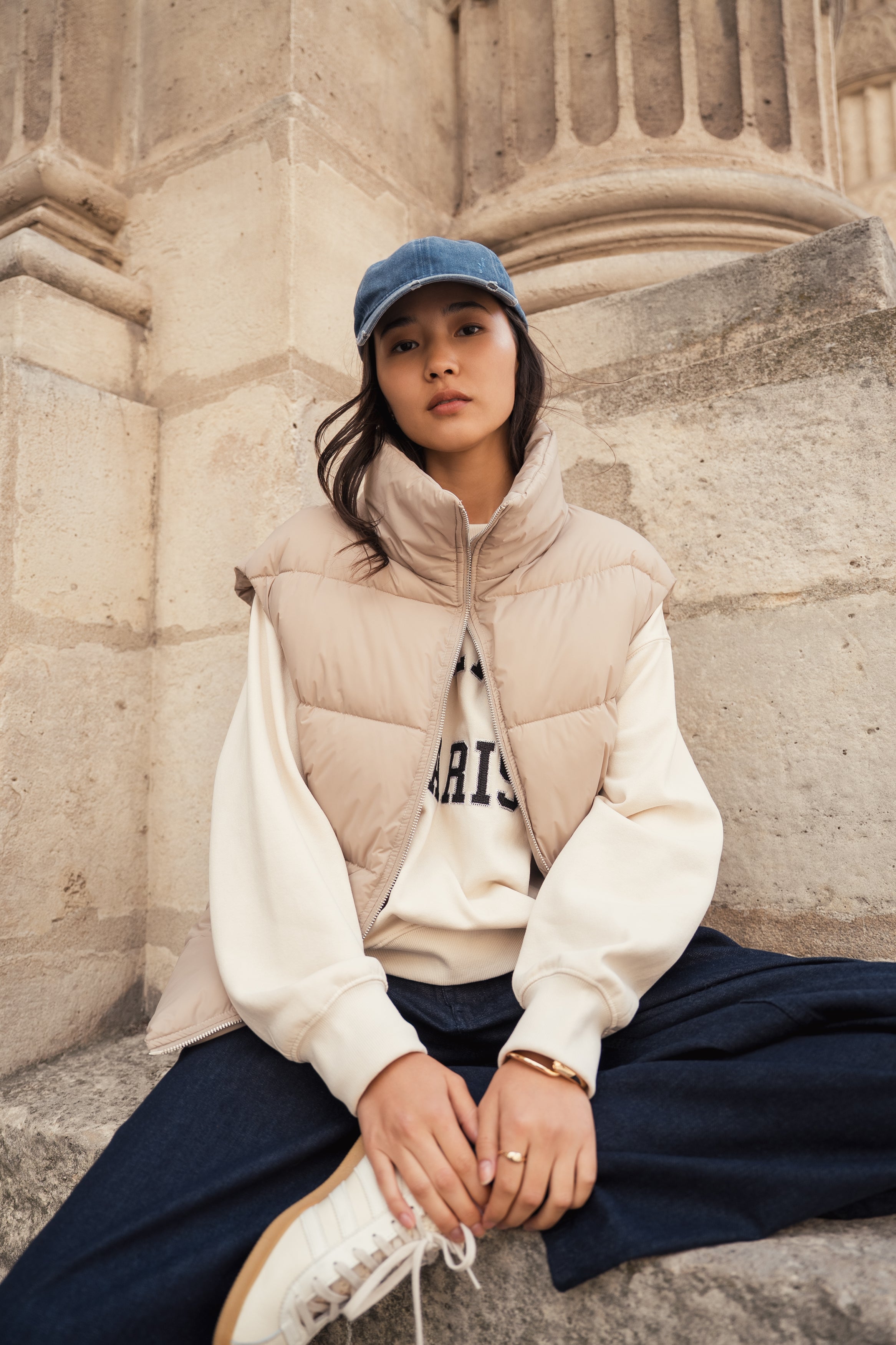 Femme portant une doudoune sans manches beige modèle Helene d'Escandelle Paris, look décontracté et chic en extérieur
#couleur_beige