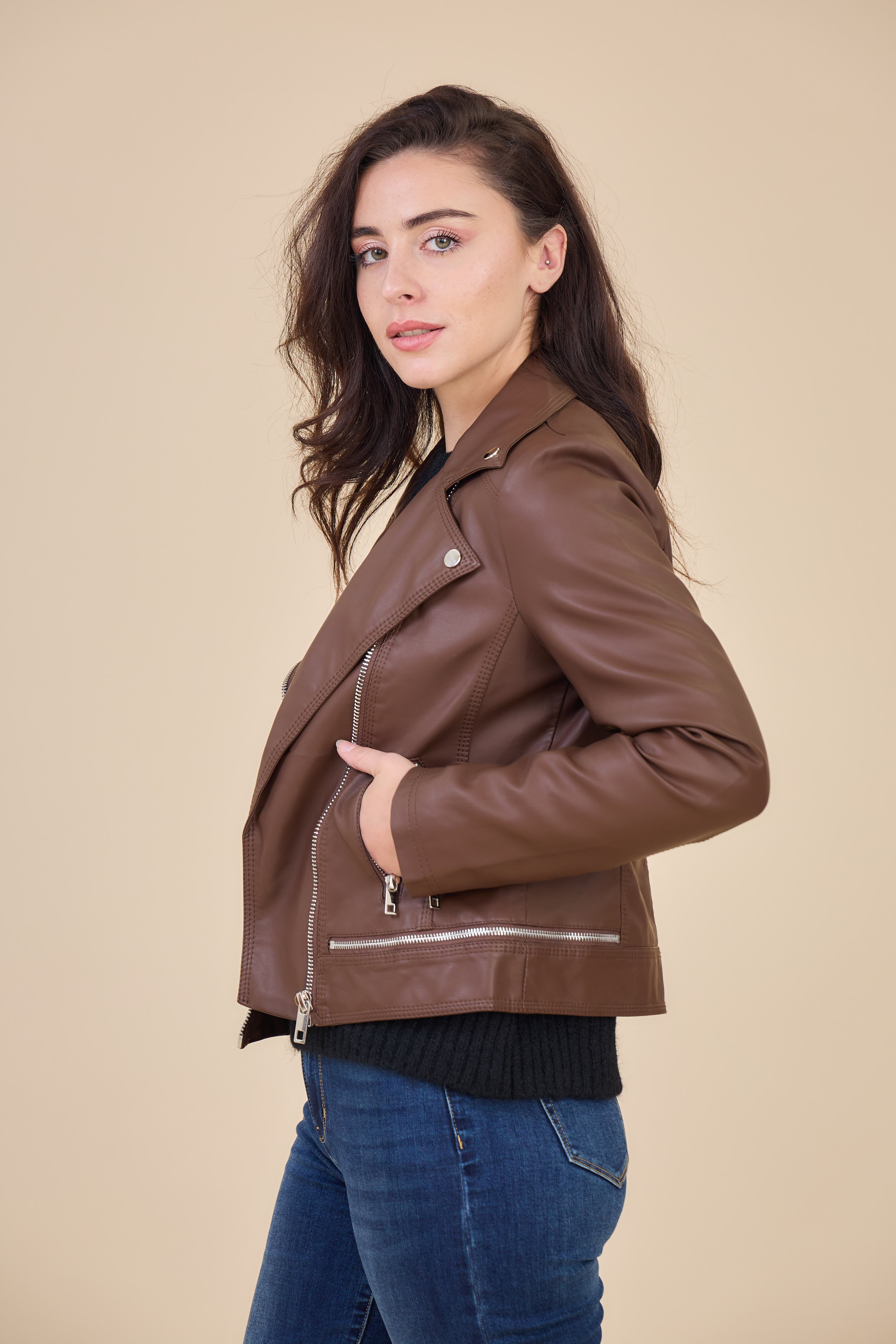 Femme portant veste en simili cuir marron avec col à revers Escandelle, fermeture zip et poches zippées – vue de profil - look chic parisien automne
#couleur_choco
