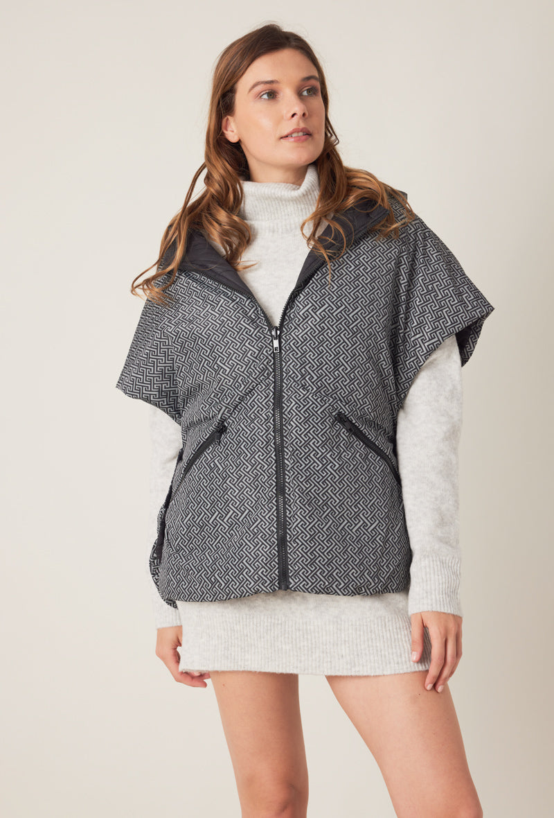 Femme portant la doudoune sans manches NORA réversible noir imprimé, avec capuche et zip frontal
#couleur_gris