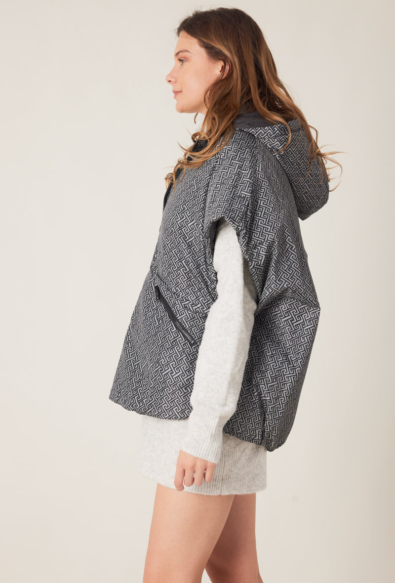 Femme portant la doudoune sans manches NORA réversible noir imprimé, avec capuche et zip frontal
#couleur_gris
