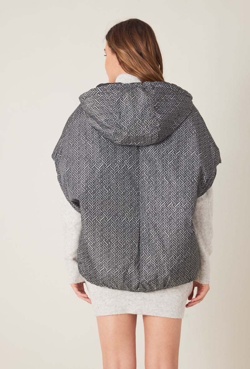 Femme portant la doudoune sans manches NORA réversible noir imprimé, avec capuche et zip frontal
#couleur_gris