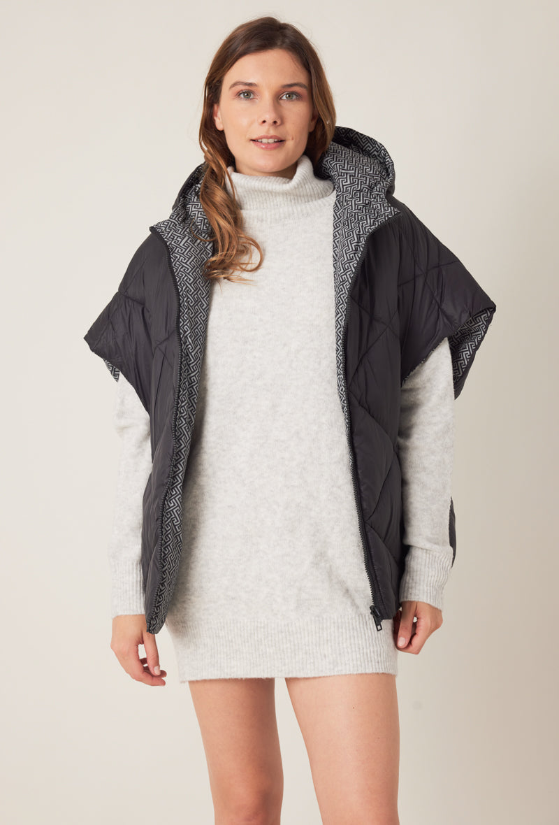 Femme portant la doudoune sans manches NORA réversible noir imprimé, avec capuche et zip frontal
#couleur_gris