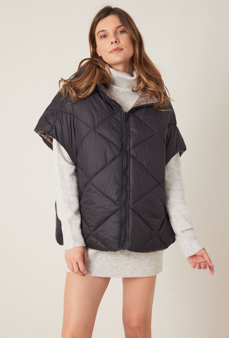 Femme portant la doudoune sans manches NORA réversible noir imprimé, avec capuche et zip frontal
#couleur_taupe