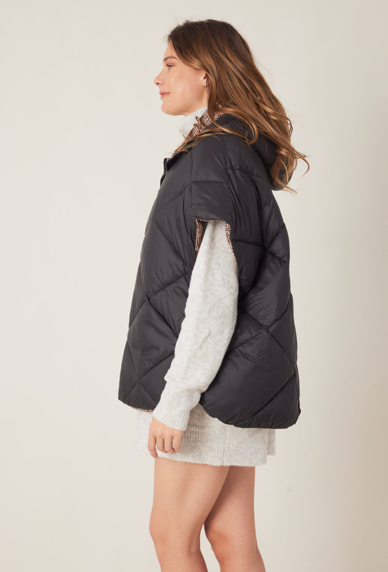 Femme portant la doudoune sans manches NORA réversible noir imprimé, avec capuche et zip frontal
#couleur_taupe