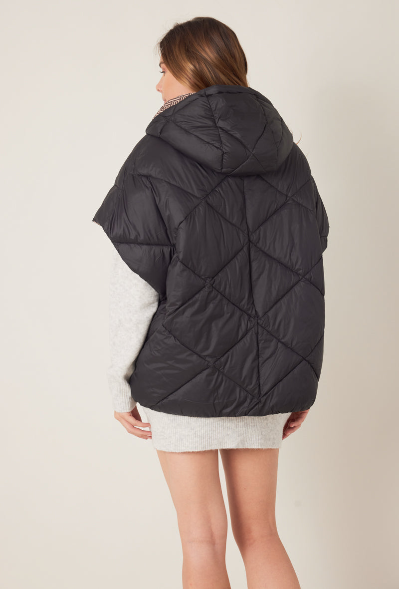 Femme portant la doudoune sans manches NORA réversible noir imprimé, avec capuche et zip frontal
#couleur_taupe