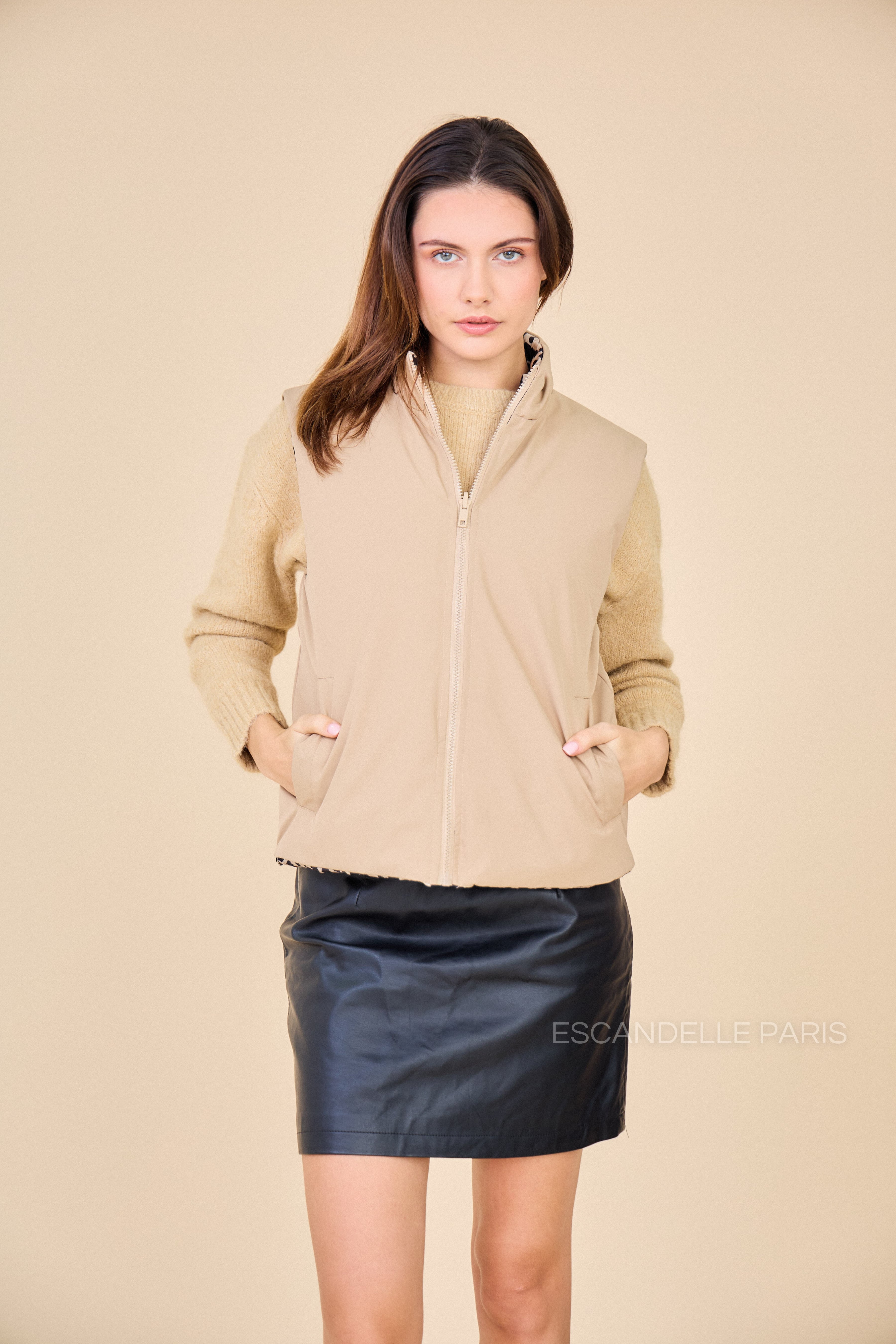 doudoune sans manches Luna, couleur beige à motifs léopard. Veste réversible. Look Escandelle Paris de dos avec jupe en similicuir et pull taupe Ola