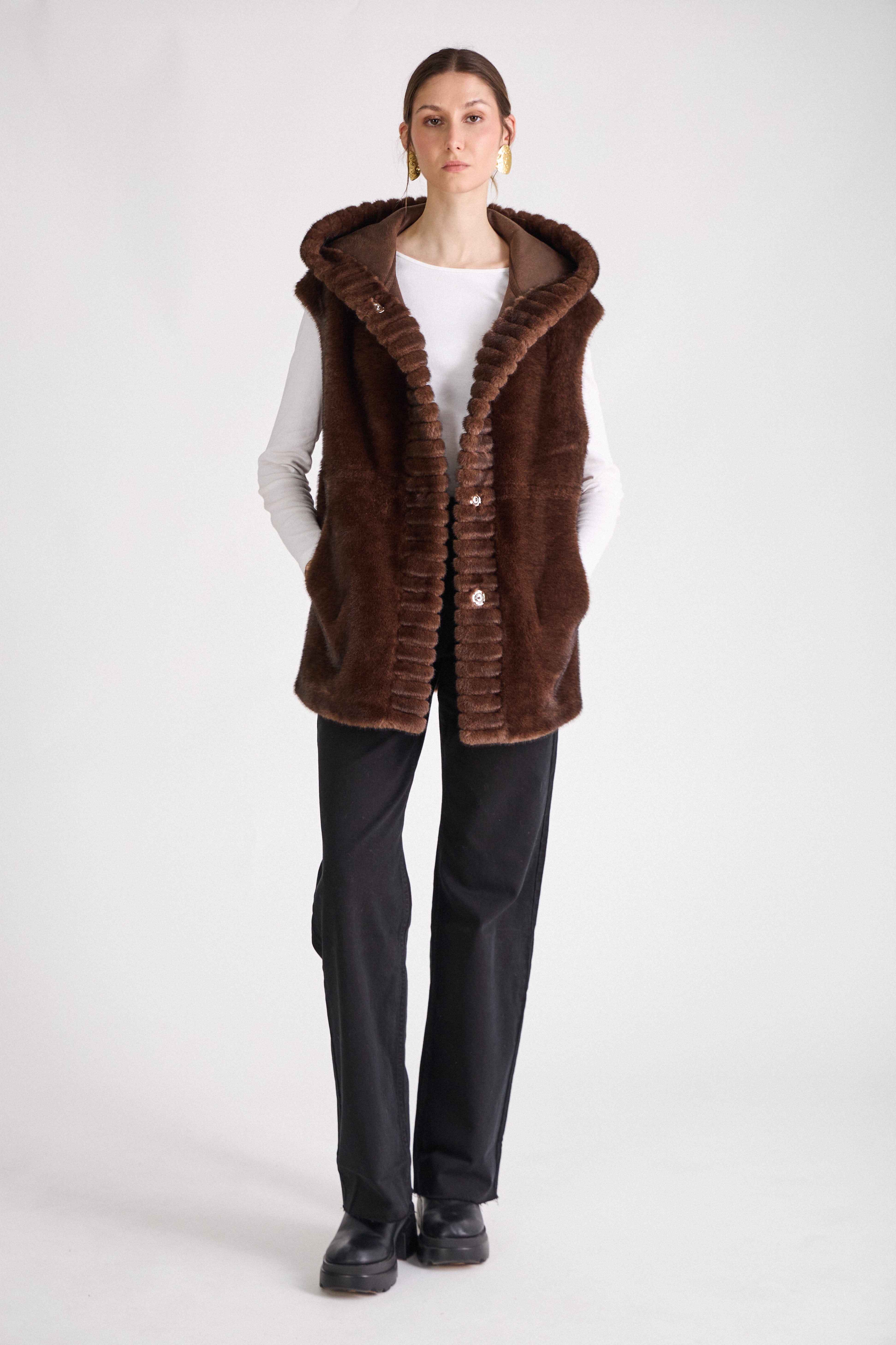 Mannequin portant le gilet sans manches CANDICE en fausse fourrure chocolat Escandelle – look studio élégant
#couleur_choco