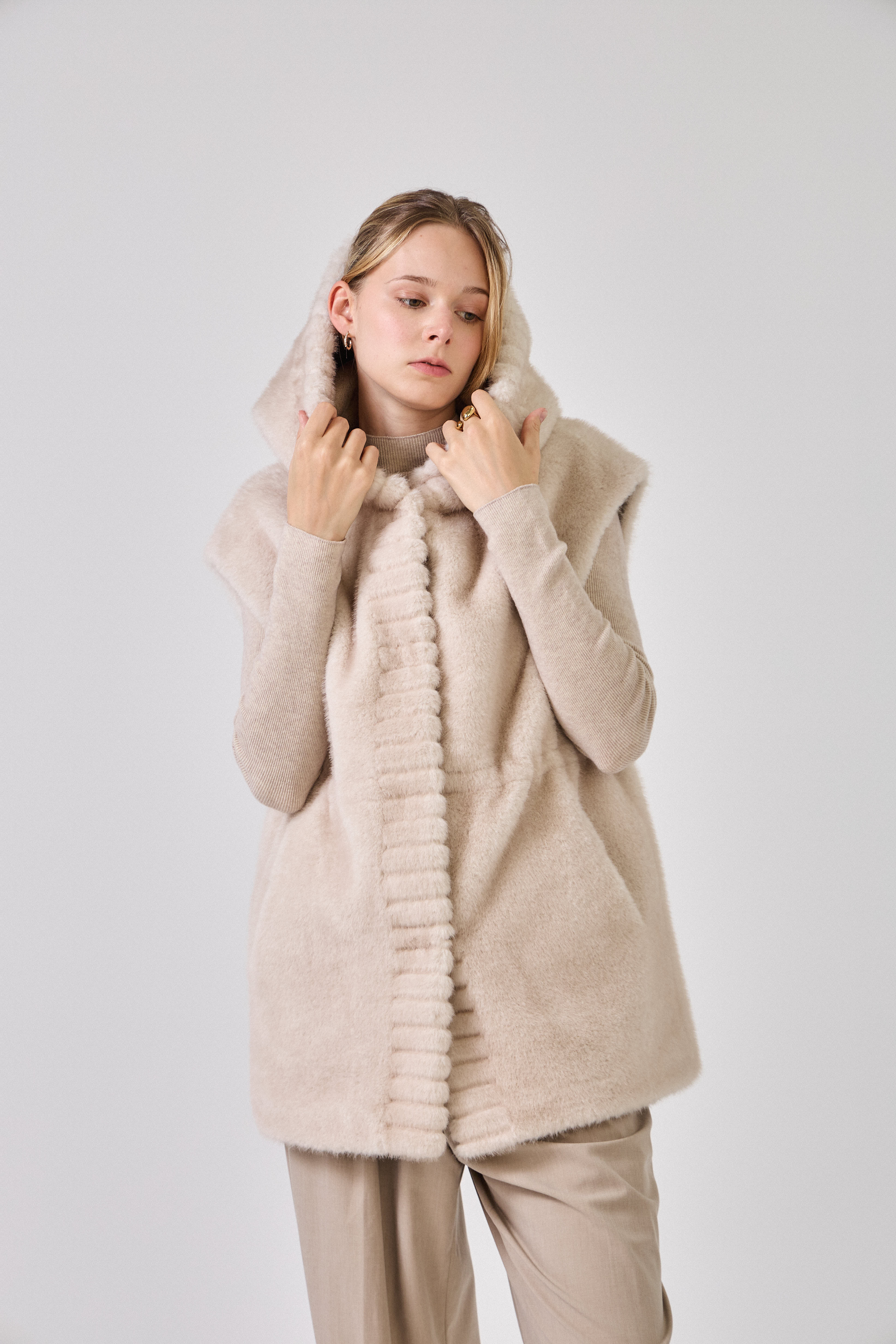 Gilet sans manches CANDICE Escandelle – vue trois-quarts – fausse fourrure beige avec poches latérales et boutons argentés
#couleur_écru