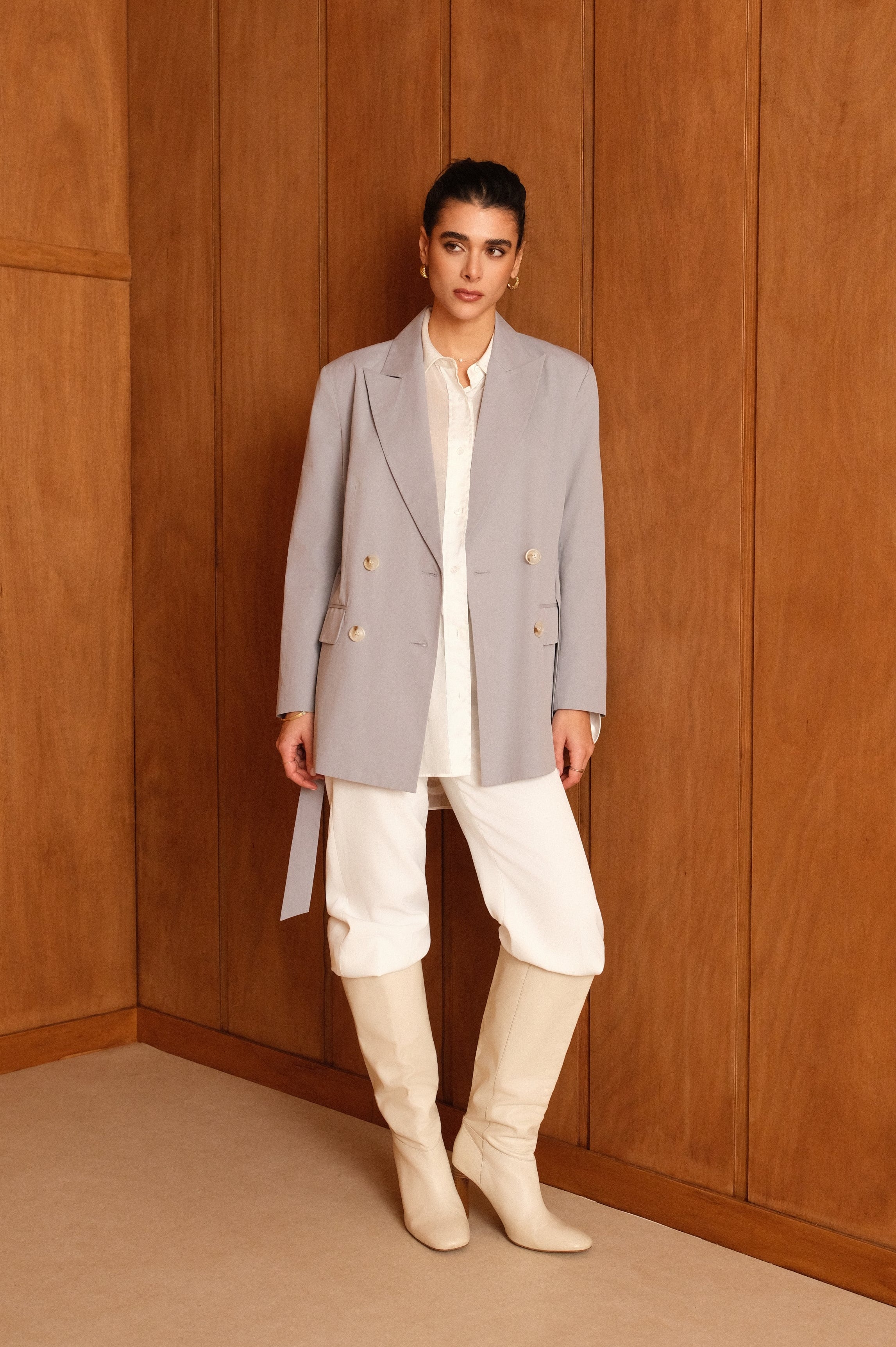 femme portant un blazer en coton bleu ciel, ceinture, boutons, col à revers, taille droit coupe élégante, devant
#couleur_ciel