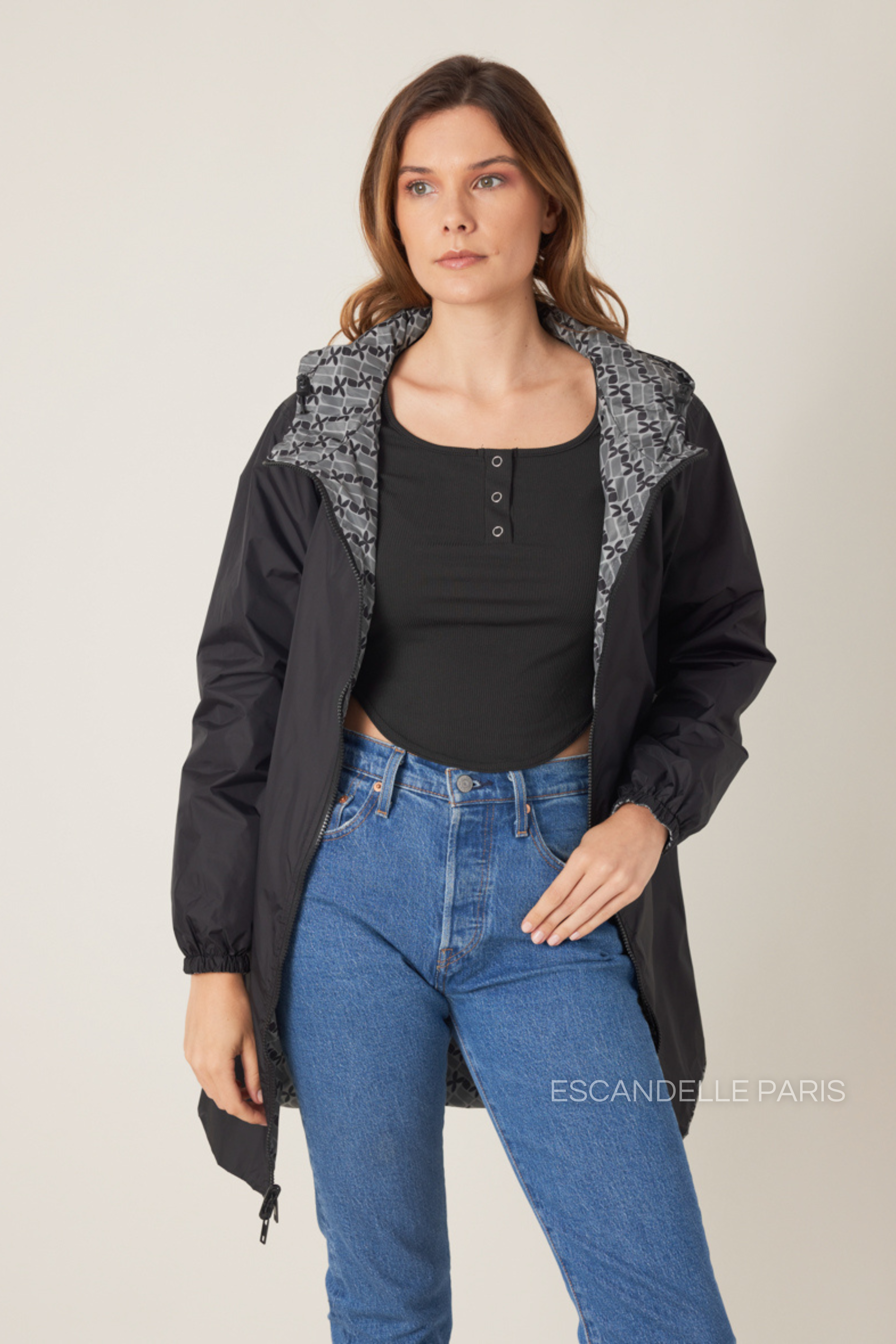 Femme portant la parka réversible LINA gris à motif géométrique, capuche dorée visible, vue de face
#couleur_gris