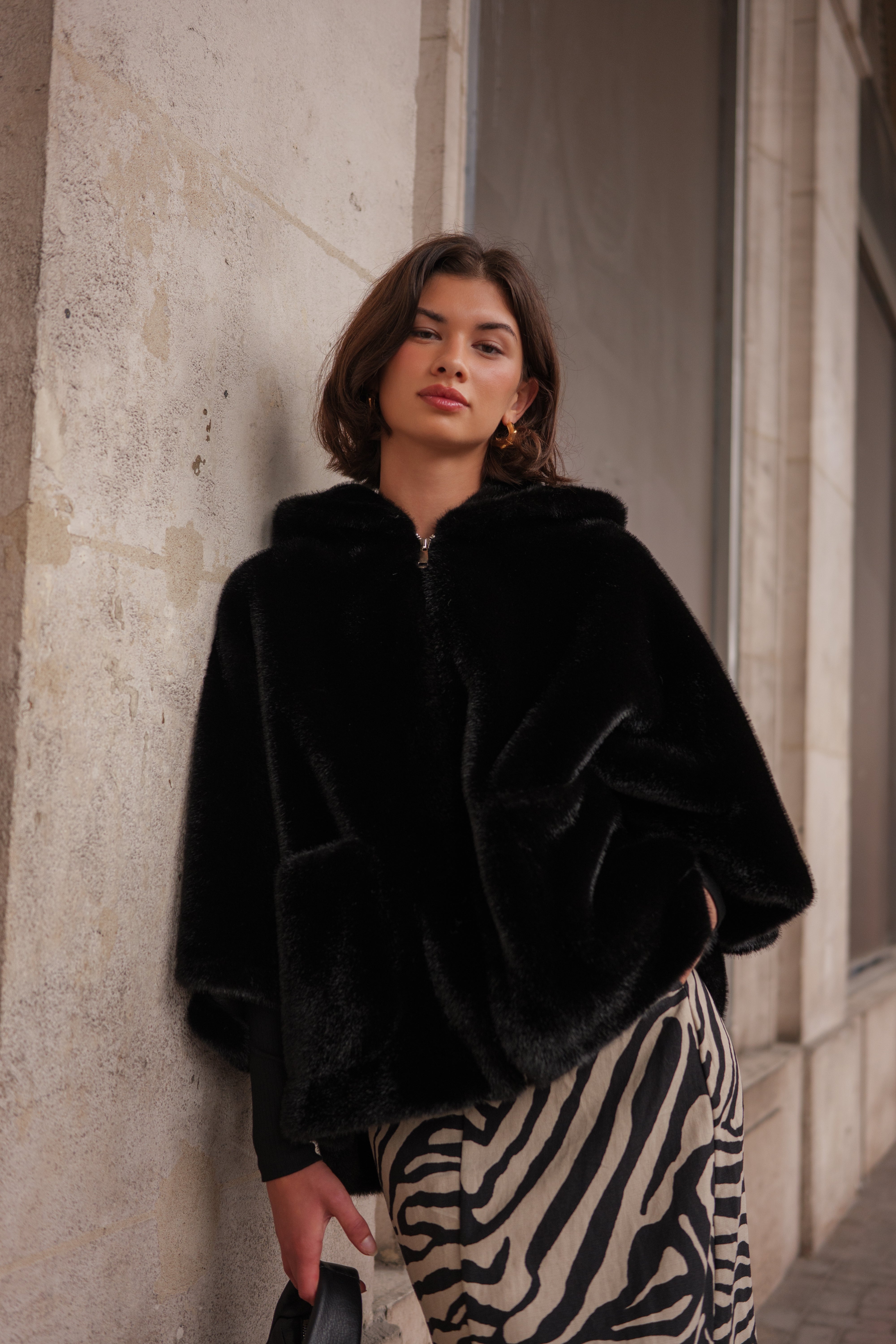 Cape en fausse fourrure ROMIE. Coupe ample, capuche enveloppante et poches latérales. Une pièce chaude, chic et confortable.
#couleur_noir