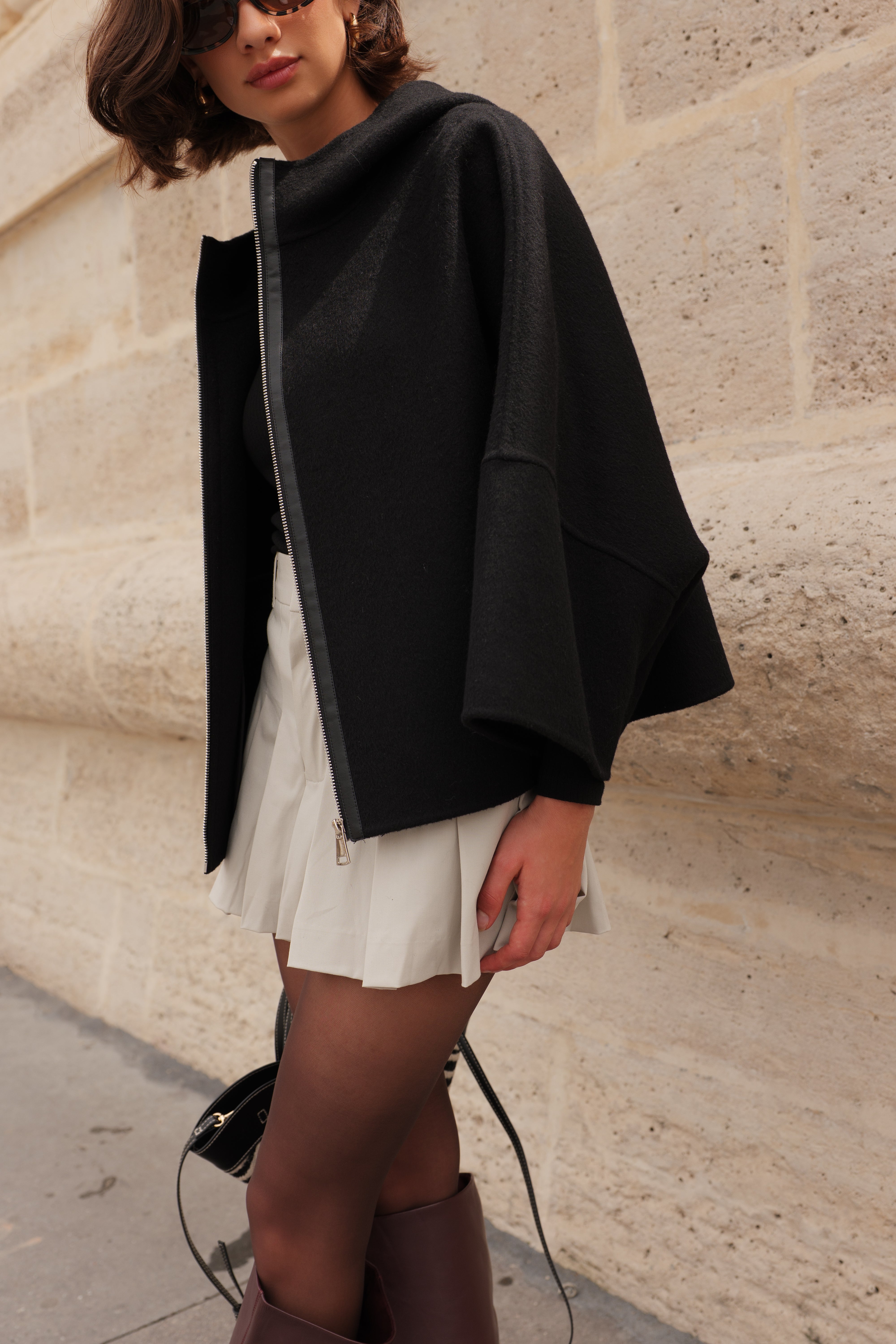 Cape ALAE Escandelle – cape en laine noire portée avec jupe plissée et accessoires modernes
#couleur_noir