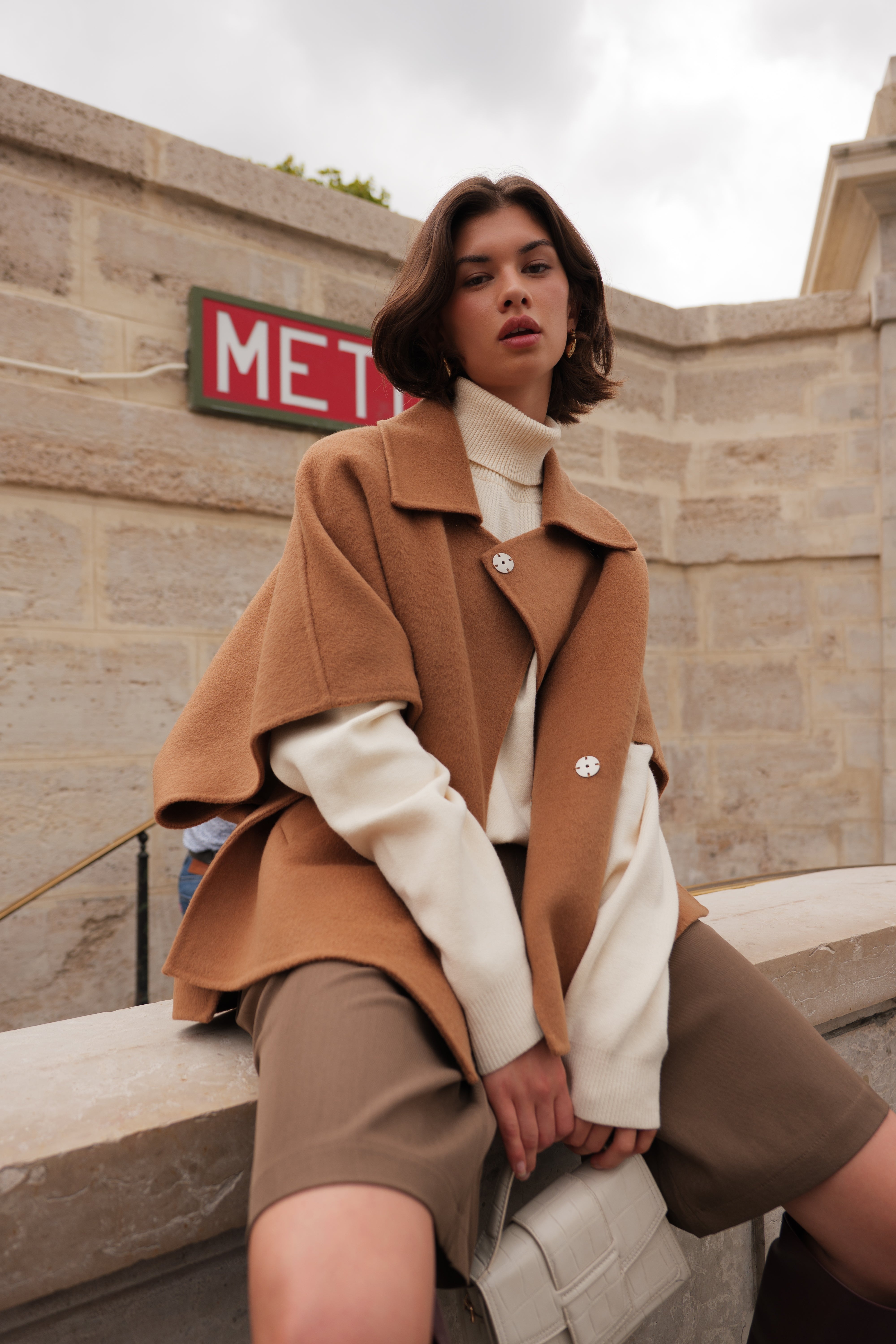 Femme portant la cape AMARA Escandelle en laine camel – vue extérieure – coupe fluide élégante avec col chemise et boutons contrastants
#couleur_camel