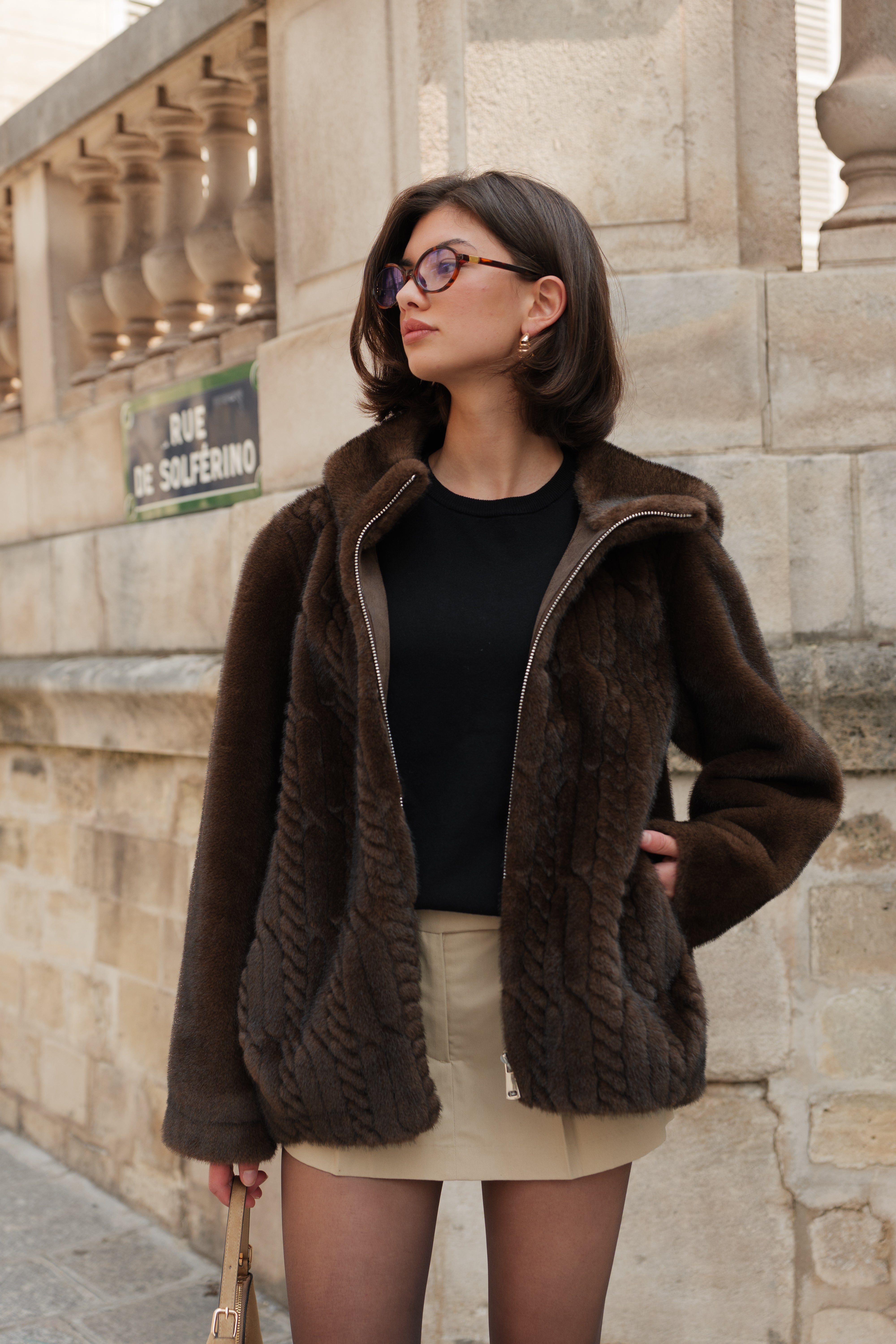 Manteau en fausse fourrure chocolat Escandelle MARILOU – photo extérieure Paris – capuche douce, texture torsadée et coupe ample élégante pour femme
#couleur_choco