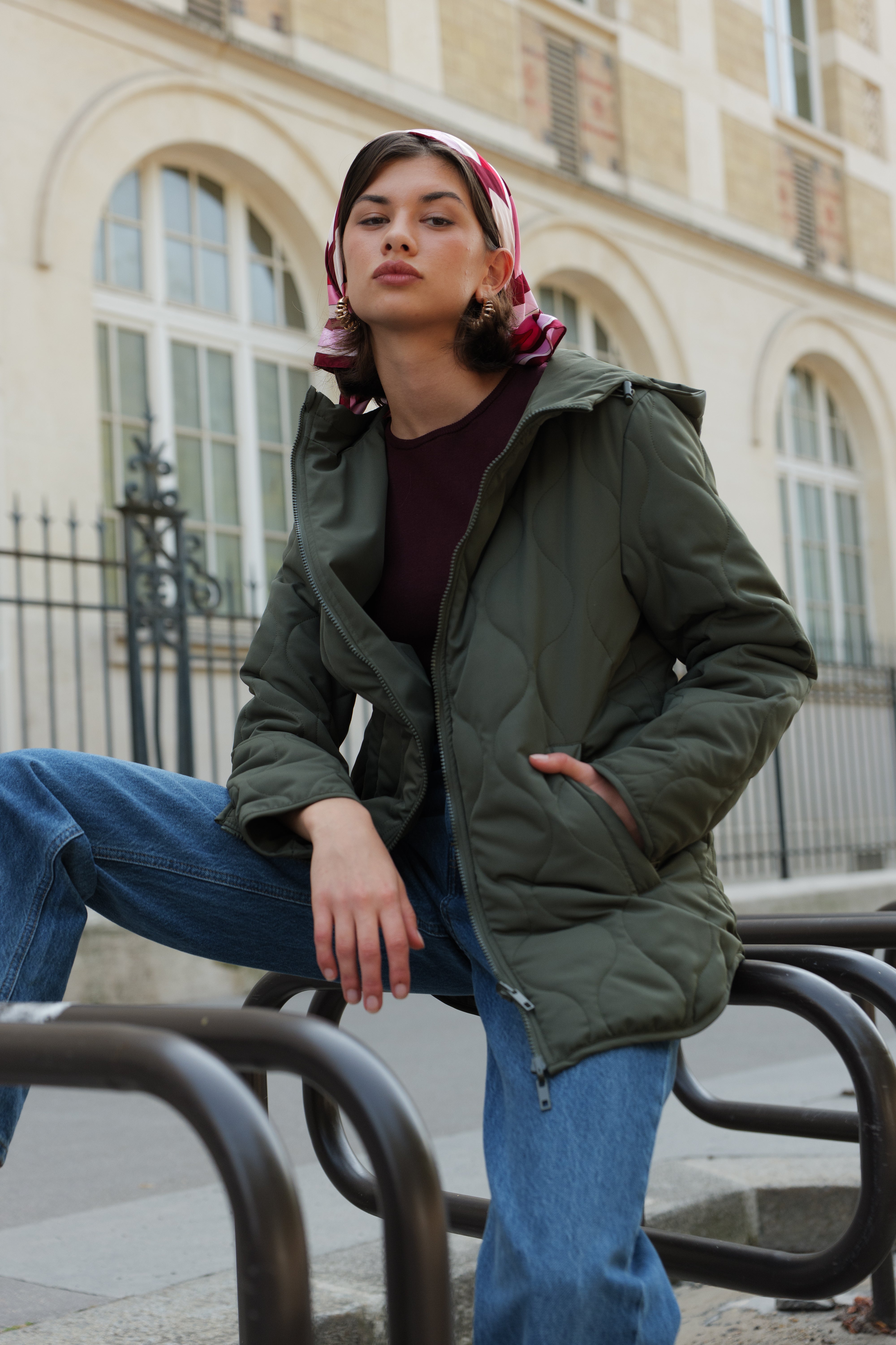 Veste matelassée kaki CASSIS Escandelle – look parisien moderne avec jean, foulard et boucles dorées.
#couleur_kaki