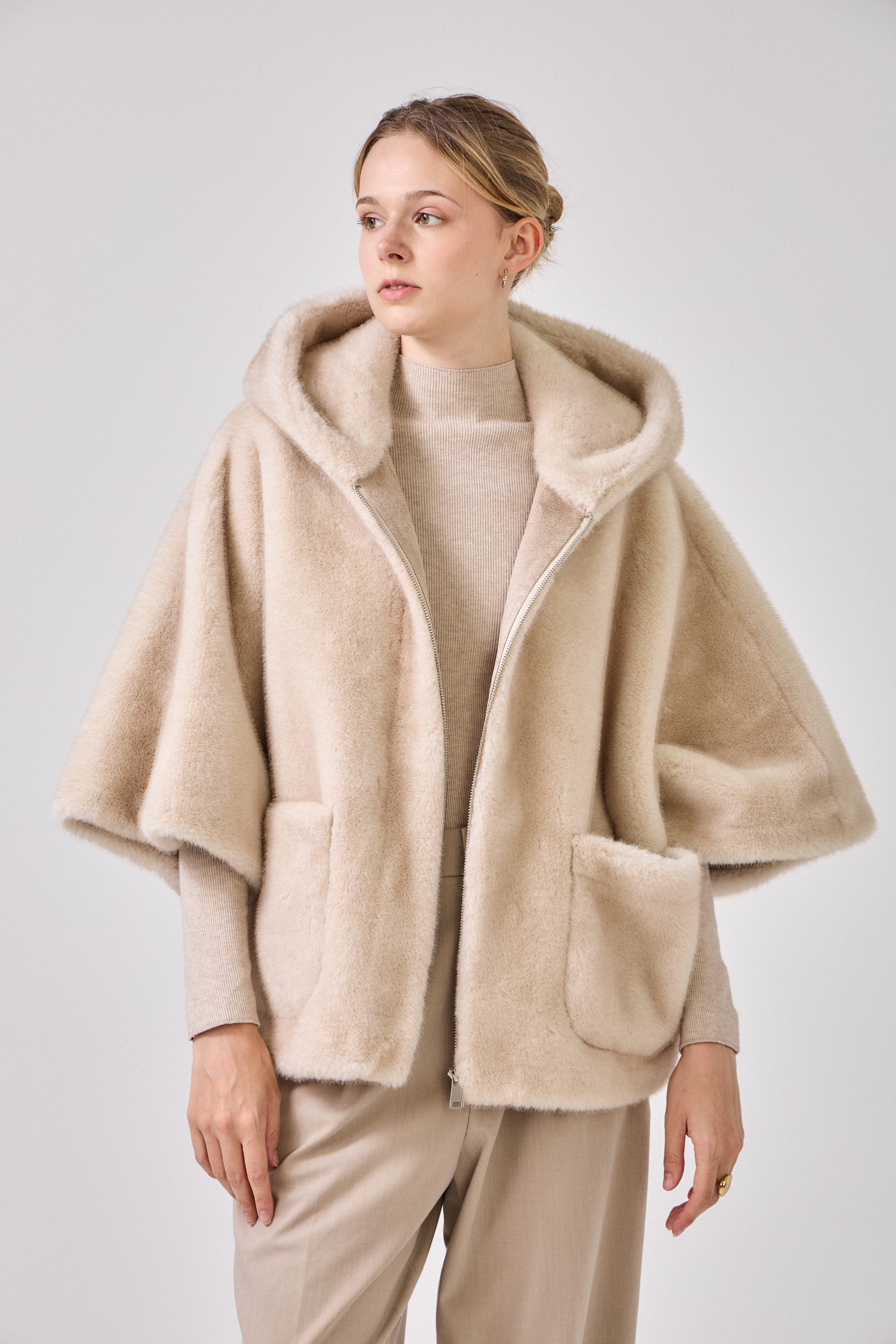 Cape en fausse fourrure ROMIE. Coupe ample, capuche enveloppante et poches latérales. Une pièce chaude, chic et confortable.
#couleur_écru