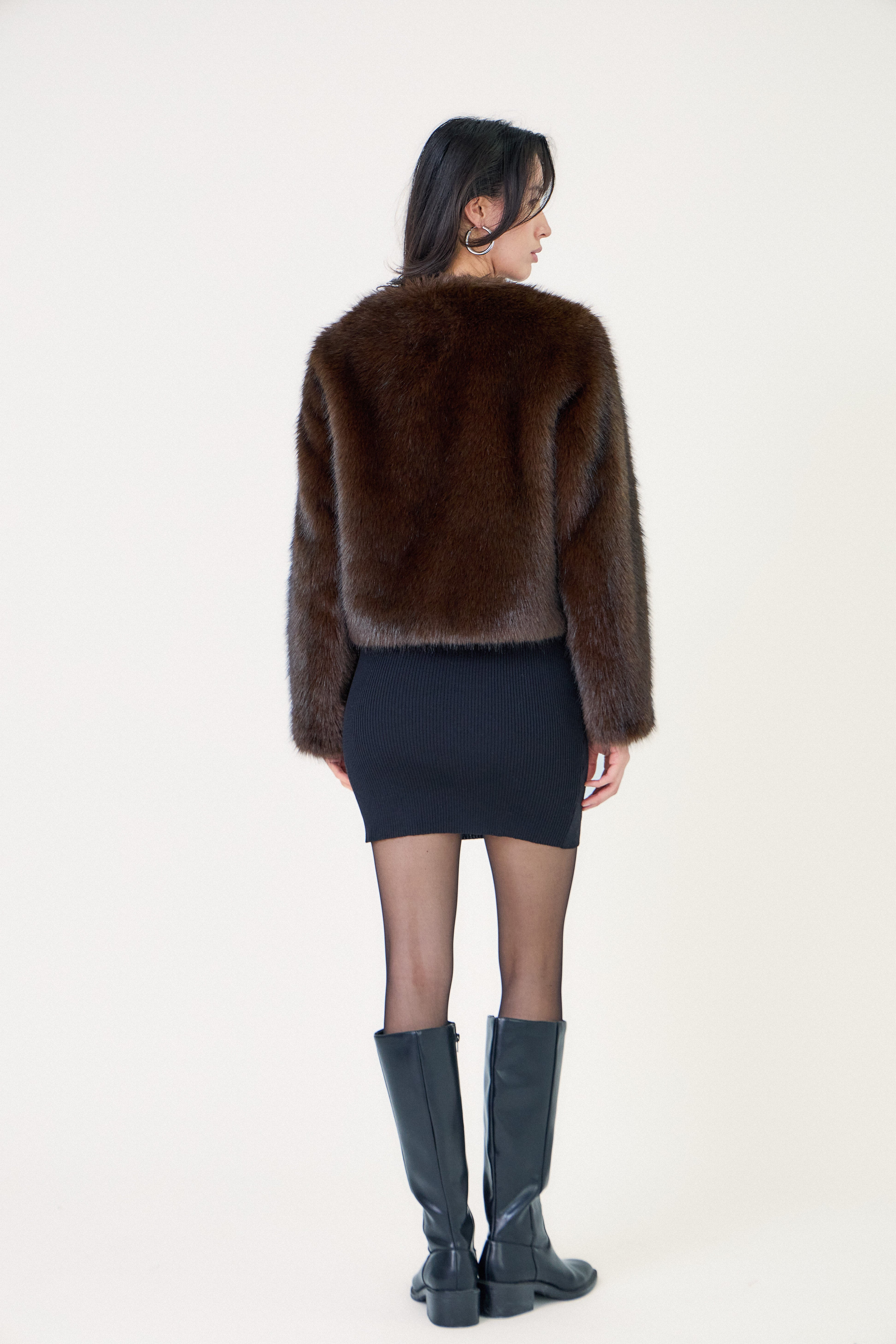 Manteau court en fausse fourrure femme Escandelle Paris, coloris choco, col rond, fermeture à pressions dissimulées, coupe élégante et poils longs doux.
#couleur_choco