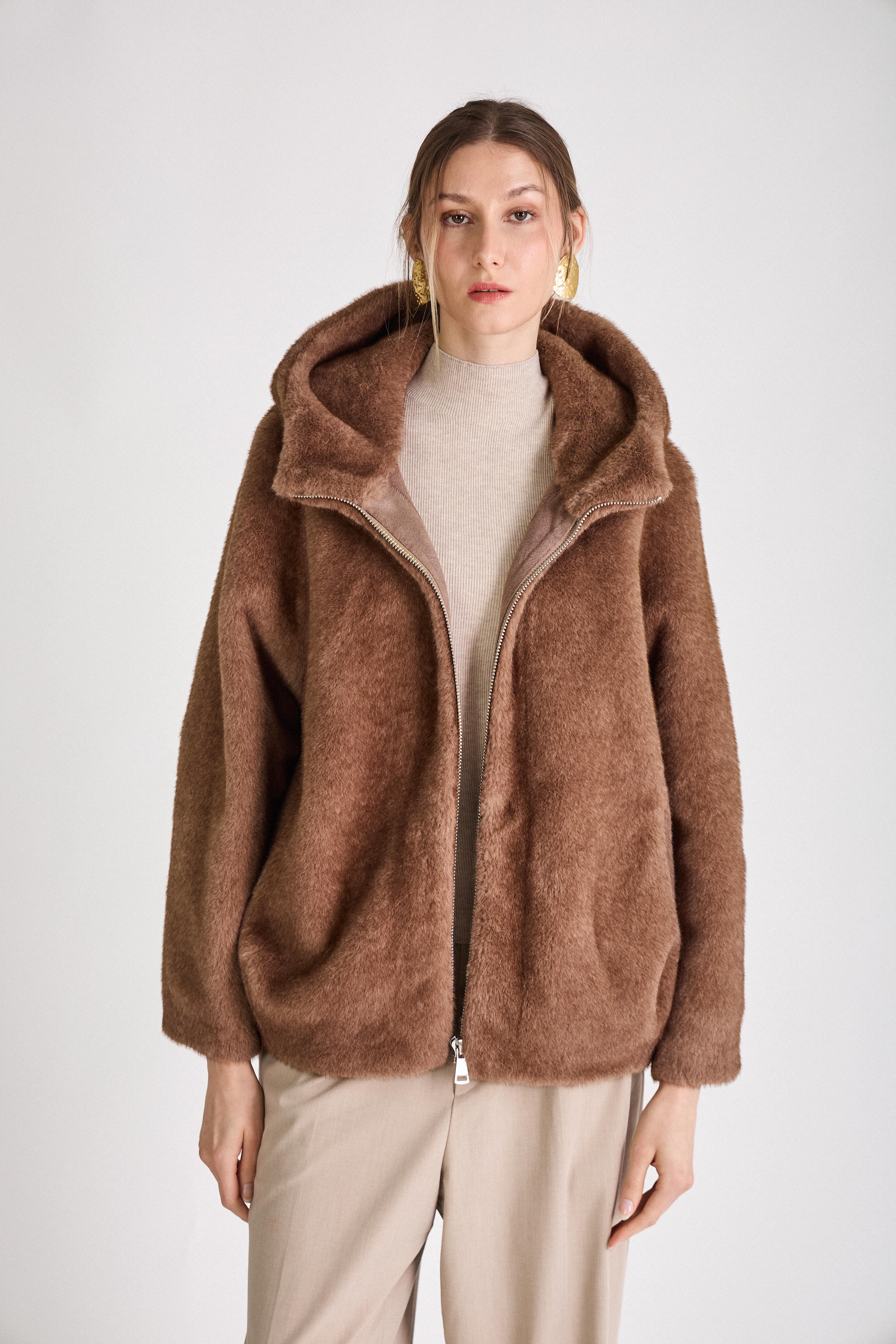 Manteau ROSY en fausse fourrure taupe – vue de face – coupe cocon avec capuche et fermeture zippée Escandelle Paris
#couleur_taupe
