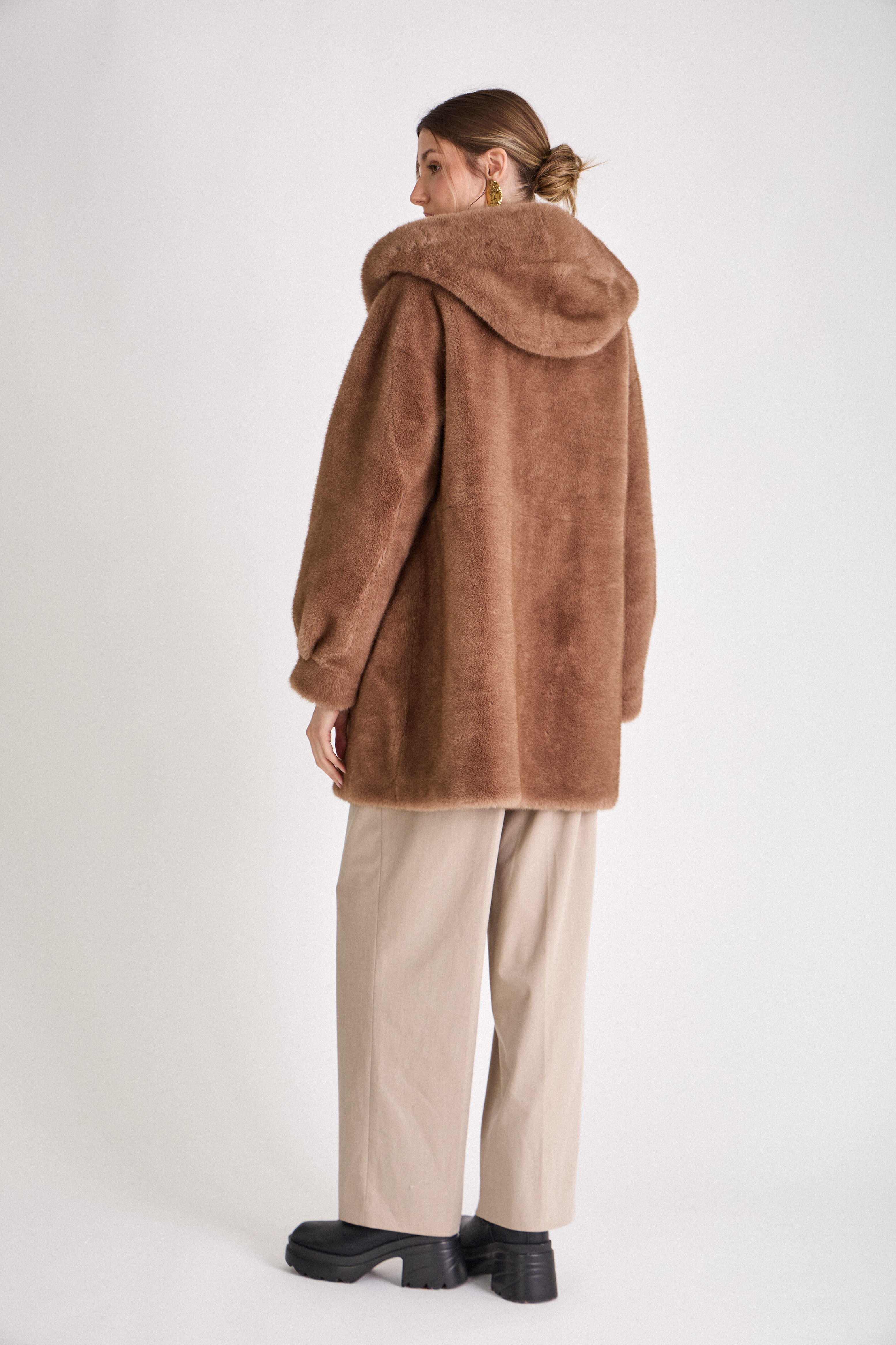Femme portant le manteau long GRACE en fausse fourrure choco, coupe droite et capuche
#couleur_taupe