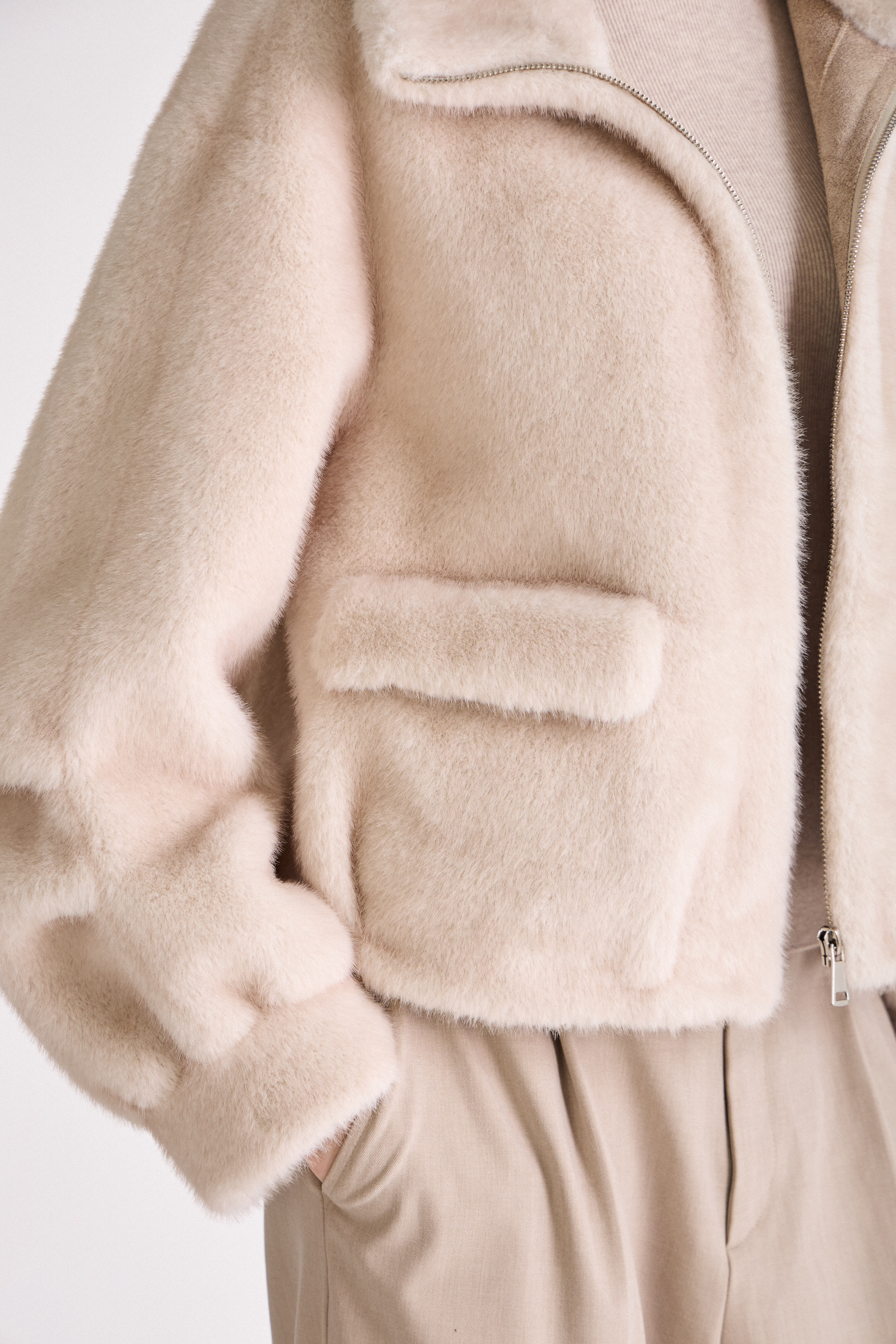 Gros plan sur les poches plaquées du manteau femme OLIVIA en fausse fourrure écru/beige Escandelle Paris
#couleur_écru