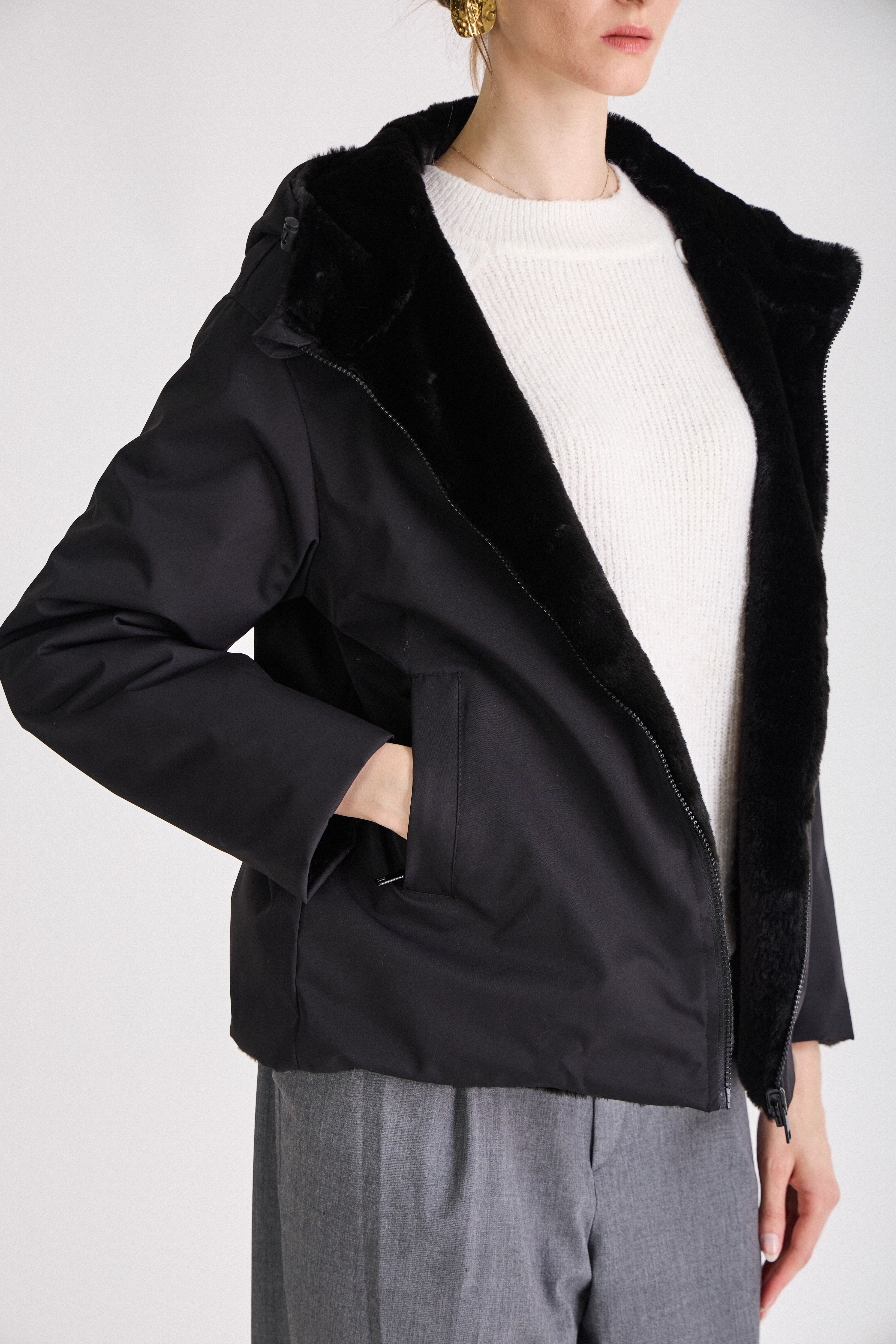 Femme portant une parka noir réversible déperlante à capuche fausse fourrure Escandelle Paris
#couleur_noir