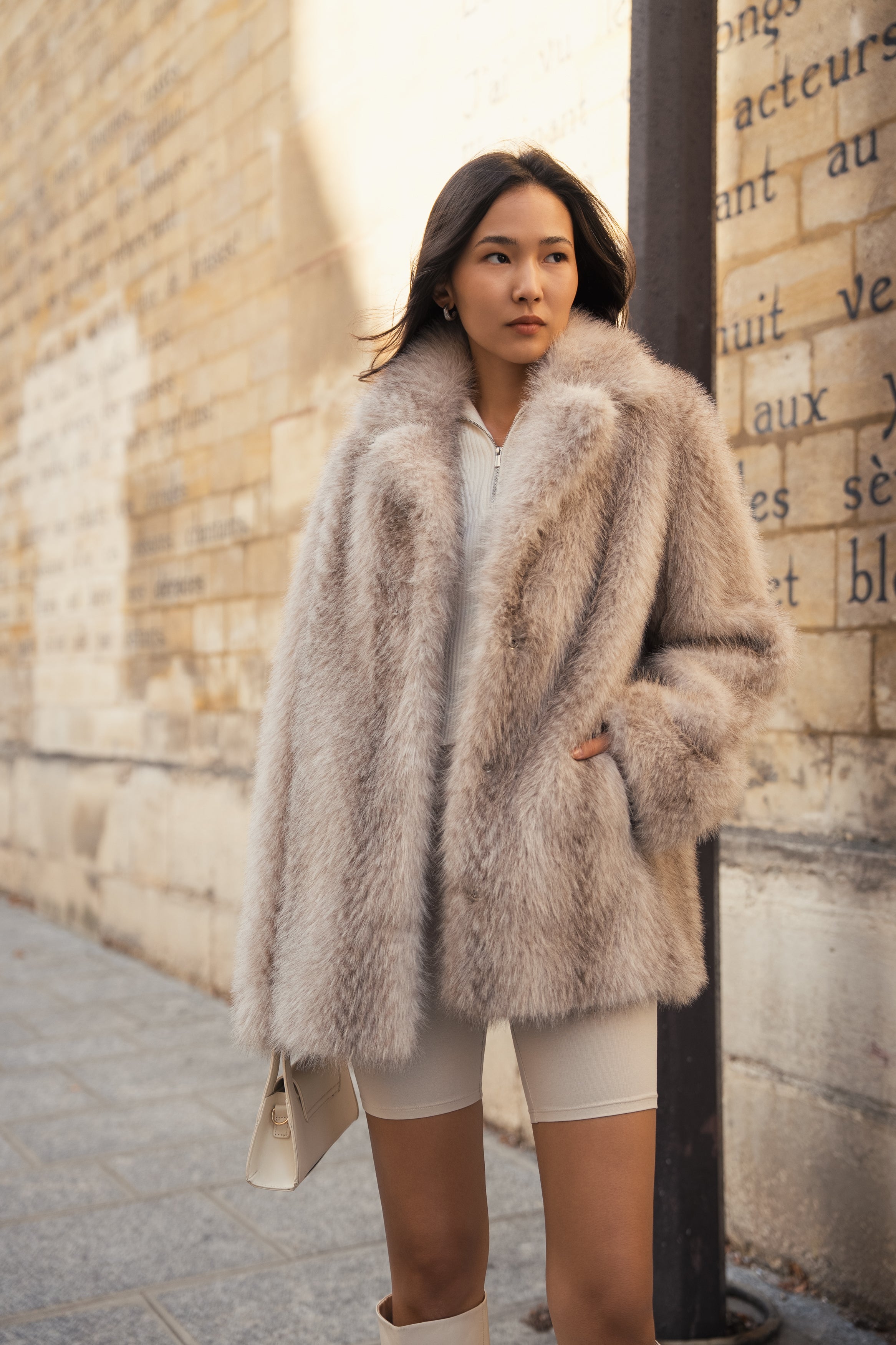 Femme portant un manteau en fourrure non animale, mi-long et oversize 
#couleur_gris