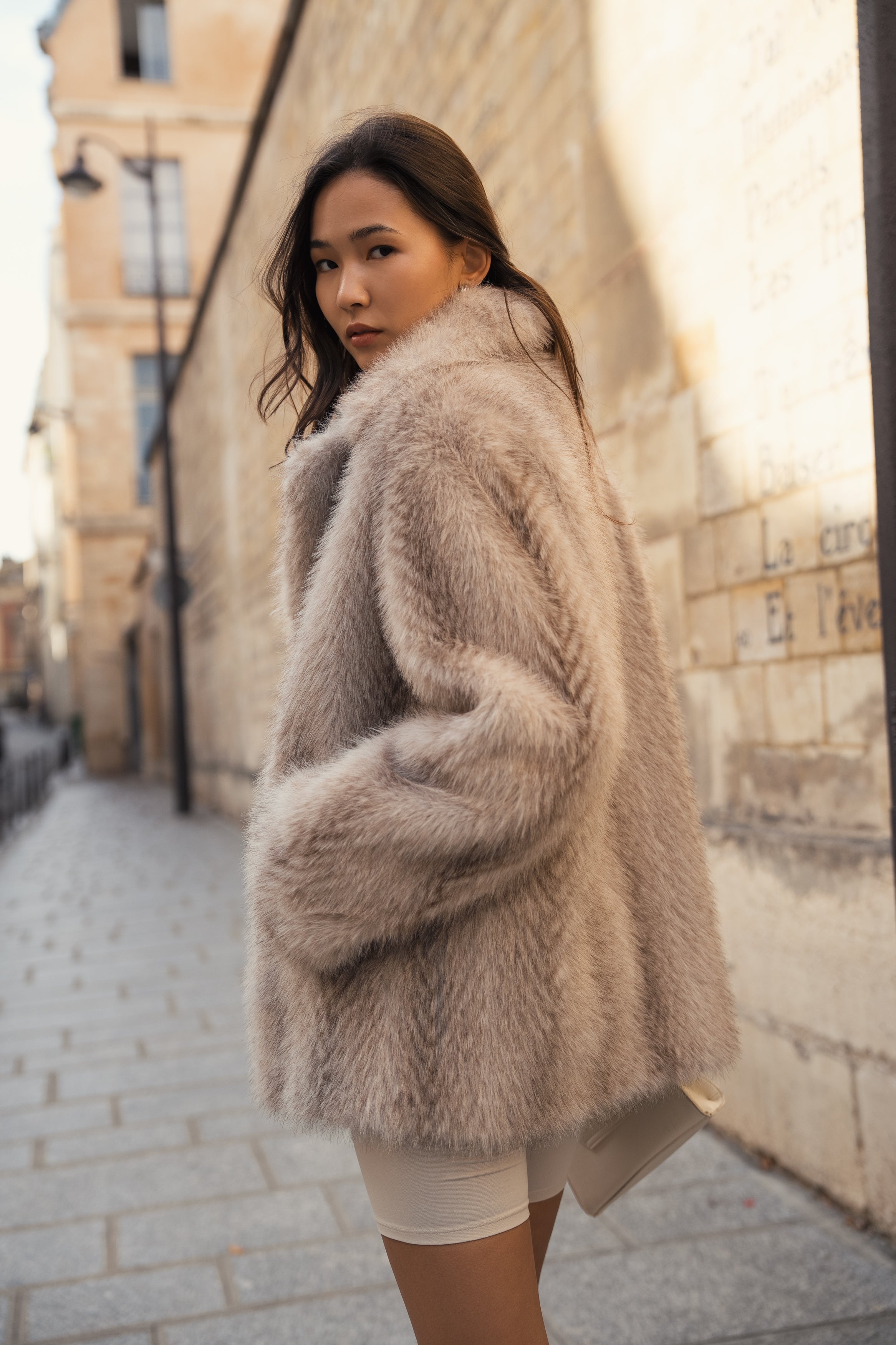 Femme portant un manteau en fourrure non animale, mi-long et oversize 
#couleur_gris