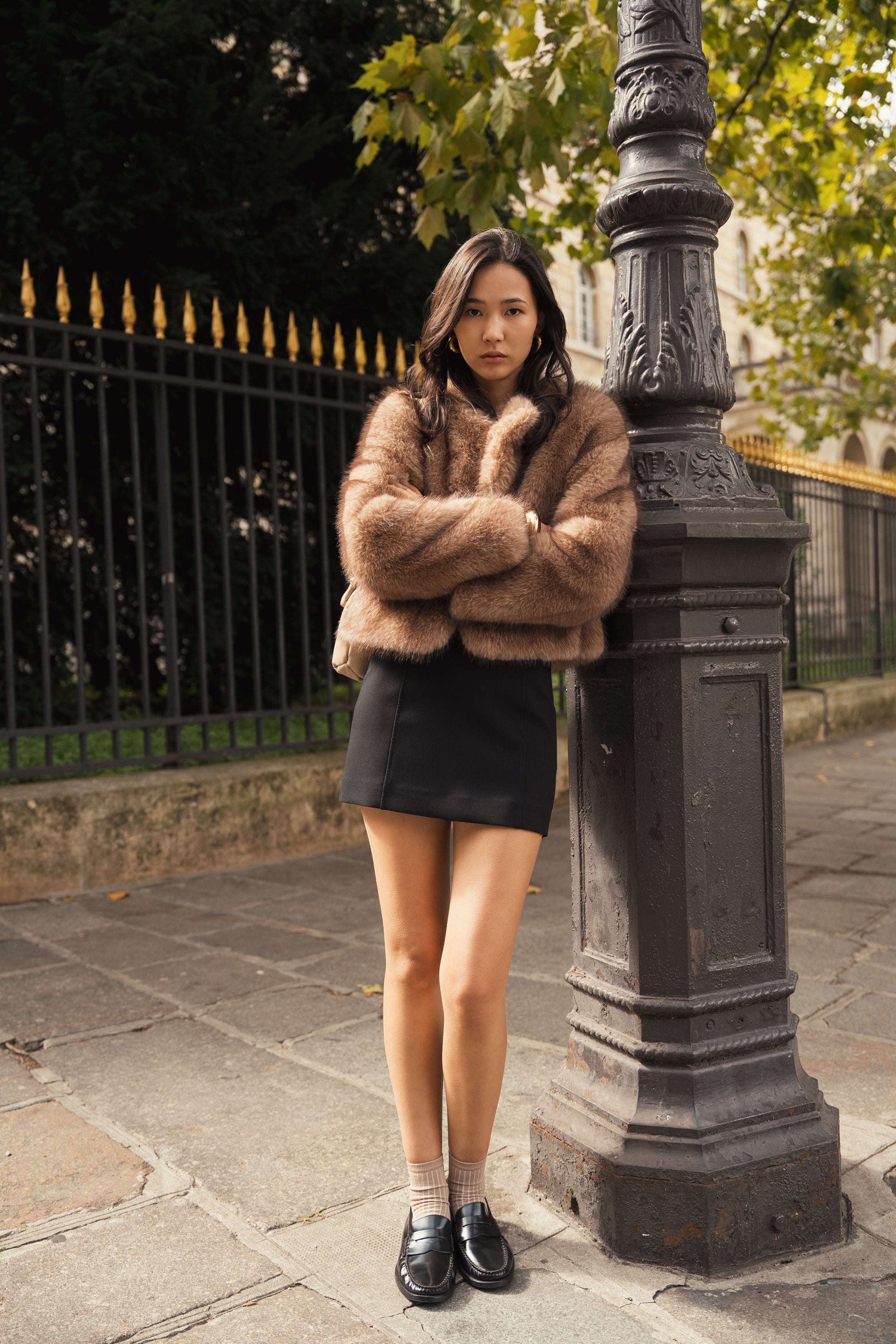 Manteau court en fausse fourrure femme Escandelle Paris, coloris brun, col rond, fermeture à pressions dissimulées, coupe élégante et poils longs doux.
#couleur_taupe