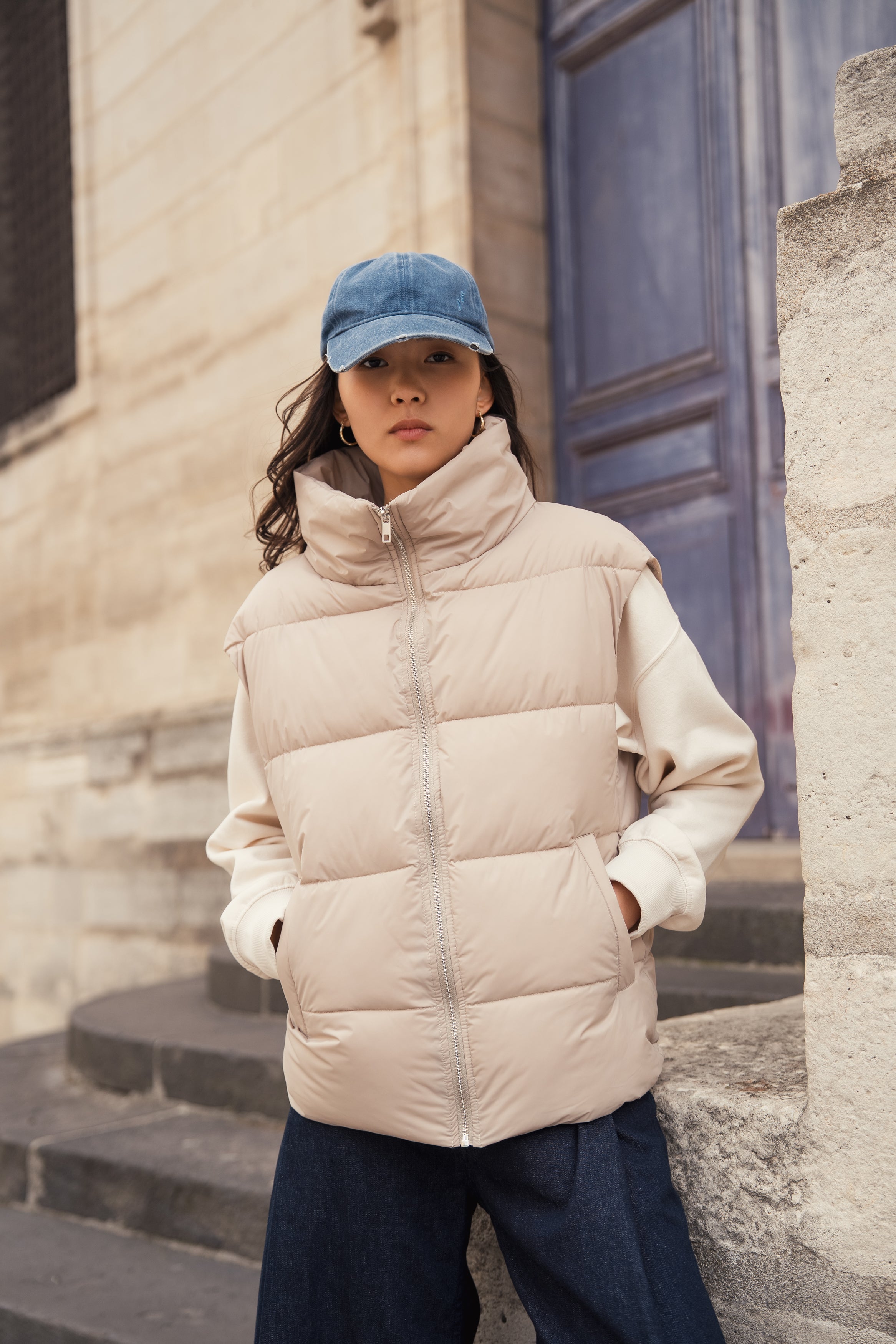 Femme portant une doudoune sans manches beige modèle Helene d'Escandelle Paris, look décontracté et chic en extérieur
#couleur_beige