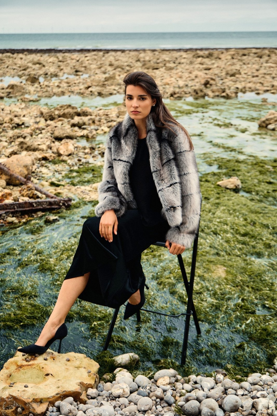 VESPER - Manteau Gris - Escandelle ( Vue de face - silhouette entière - mannequin assis sur une chaise) 
#couleur_gris