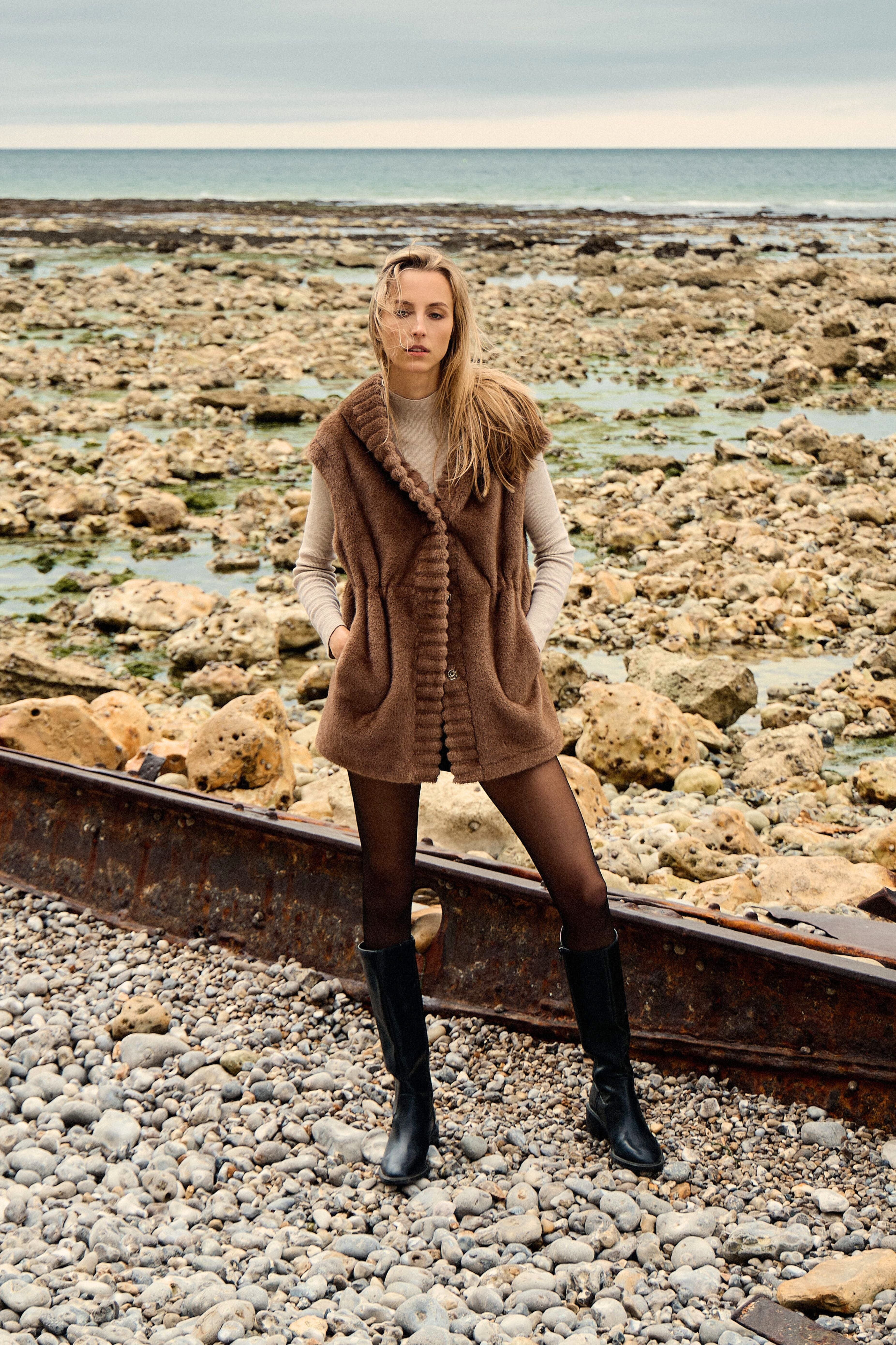 Gilet CANDICE Escandelle – vue de dos – coupe droite mi-longue en fausse fourrure taupe douce - resserage à la taille
#couleur_taupe