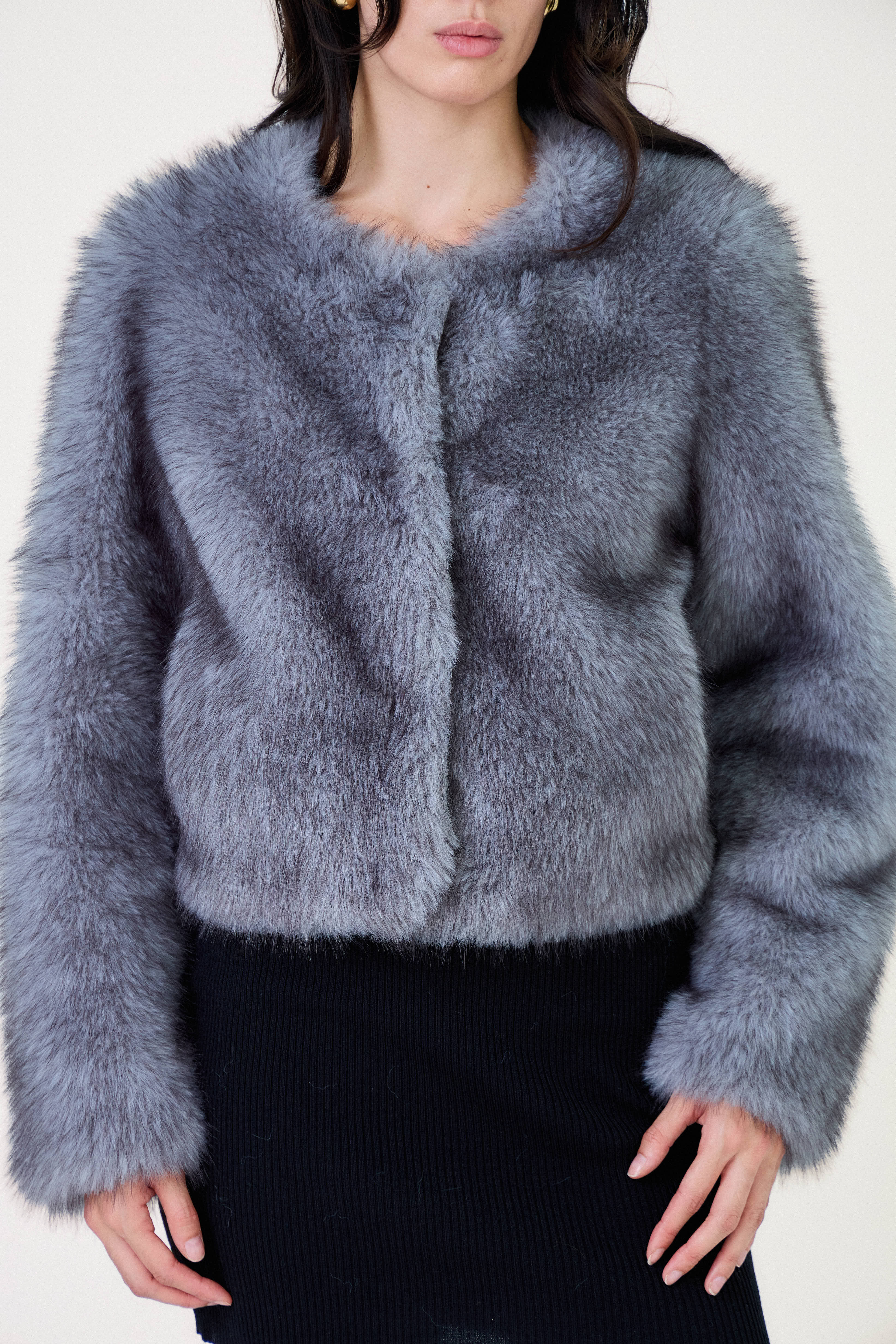 Manteau court en fausse fourrure femme Escandelle Paris, coloris gris, col rond, fermeture à pressions dissimulées, coupe élégante et poils longs doux.
#couleur_gris