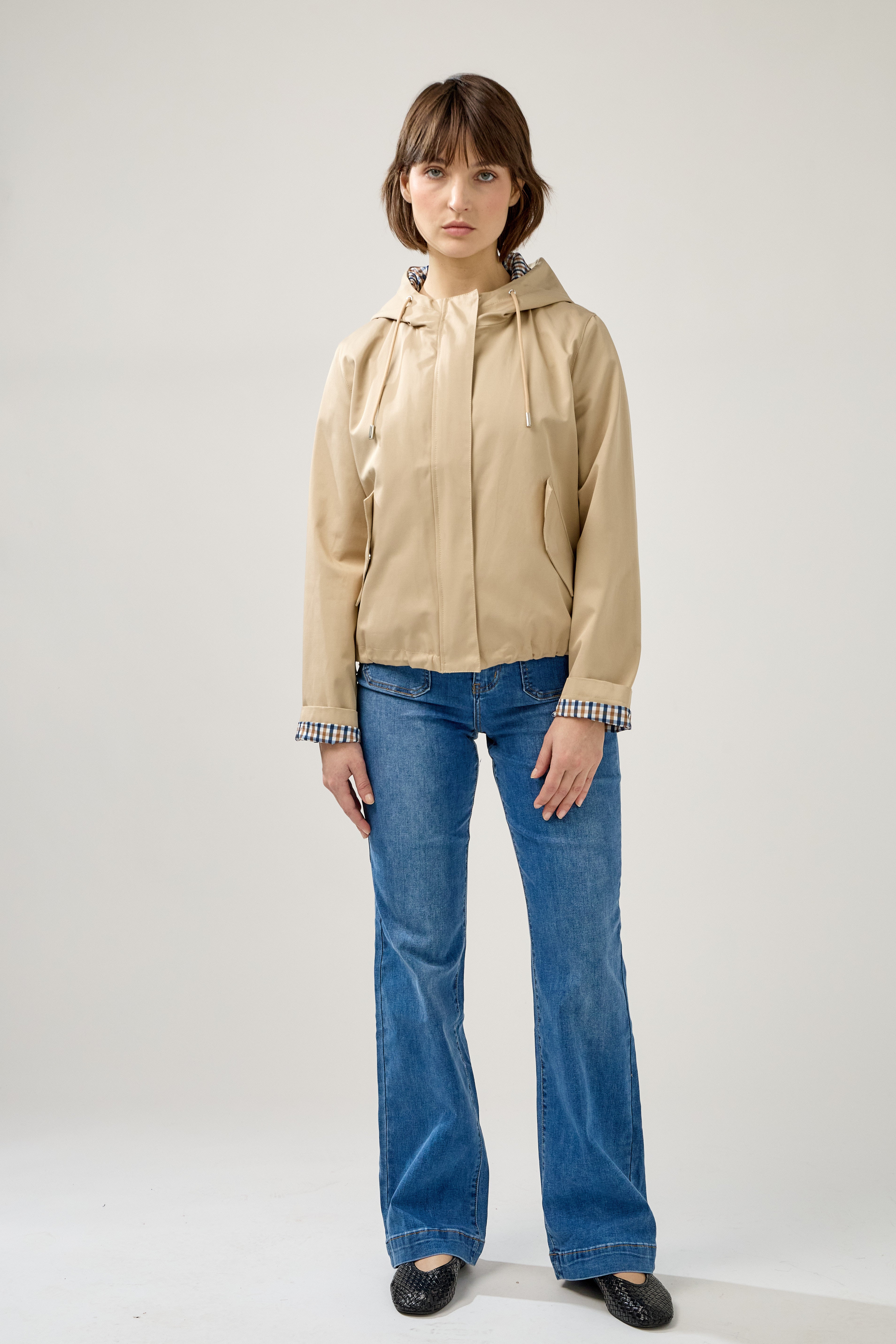 veste coton imperméable à capuche cordons, doublure à carreaux, poches à rabats et bouton pression, fermeture à glissière métallique cachée, bas avec élastique, devant
#couleur_beige