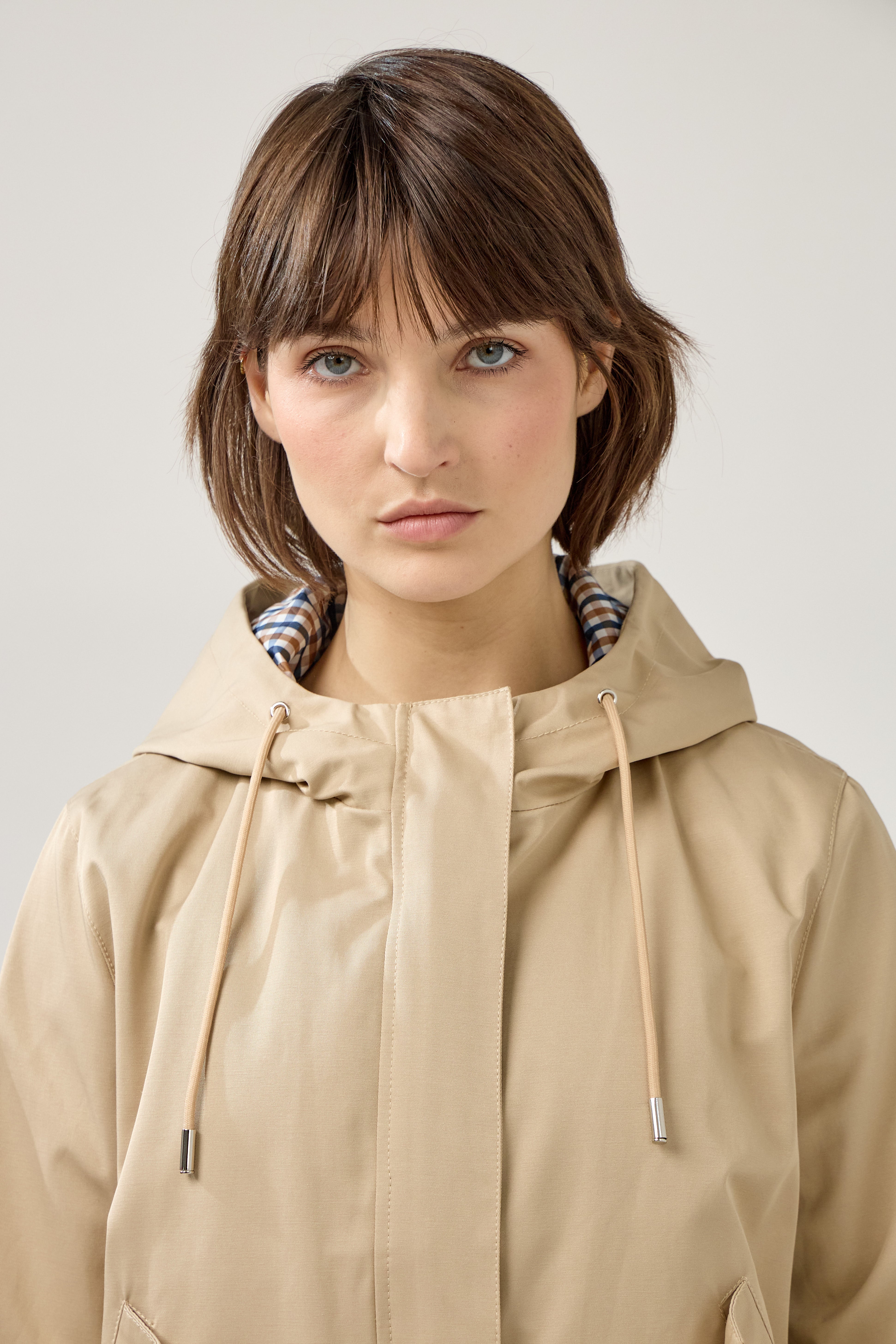 veste coton imperméable à capuche cordons, doublure à carreaux, fermeture à glissière métallique cachée, zoom devant
#couleur_beige