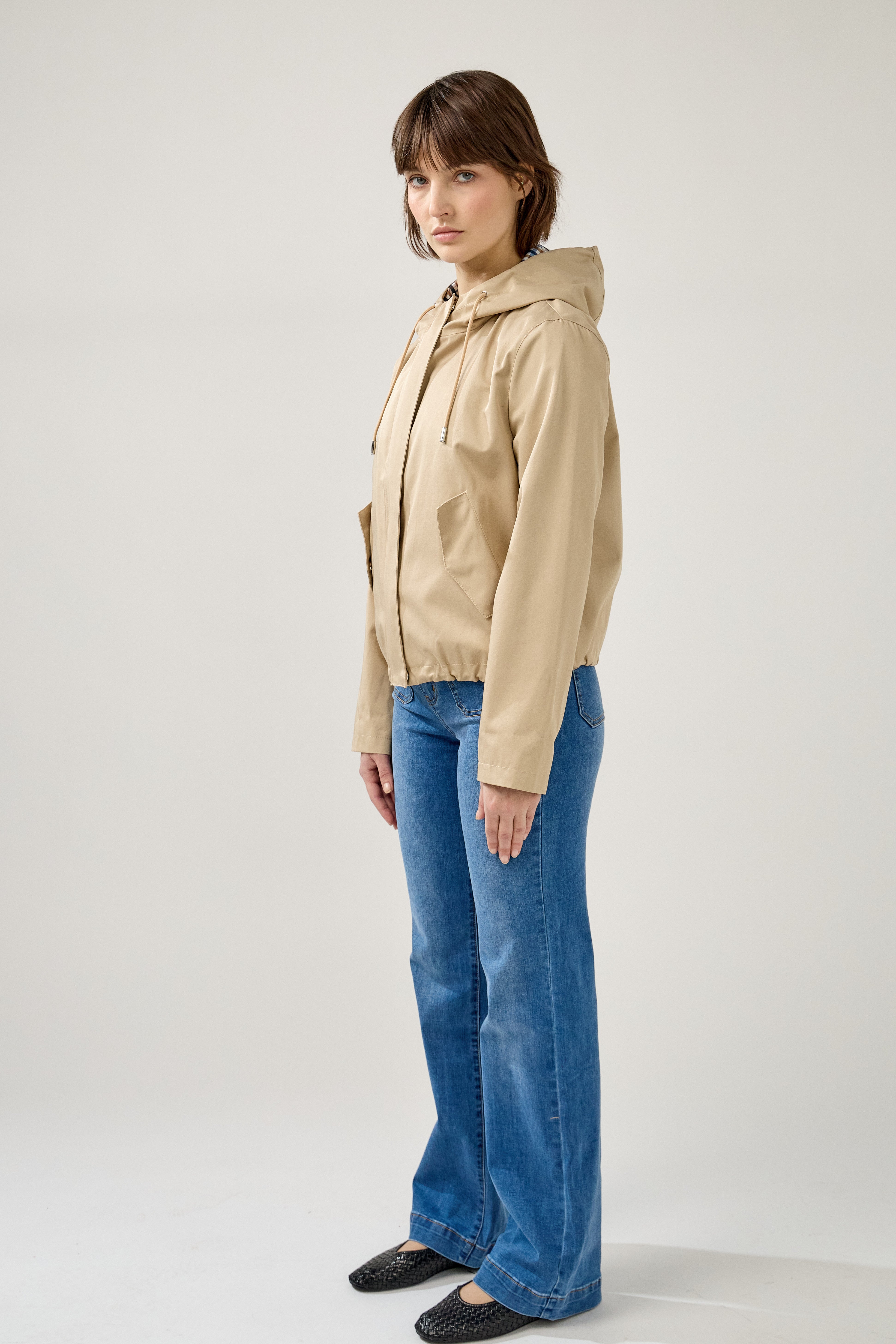veste coton imperméable à capuche cordons, doublure à carreaux, poches à rabats et bouton pression, fermeture à glissière métallique cachée, bas avec élastique, profil
#couleur_beige