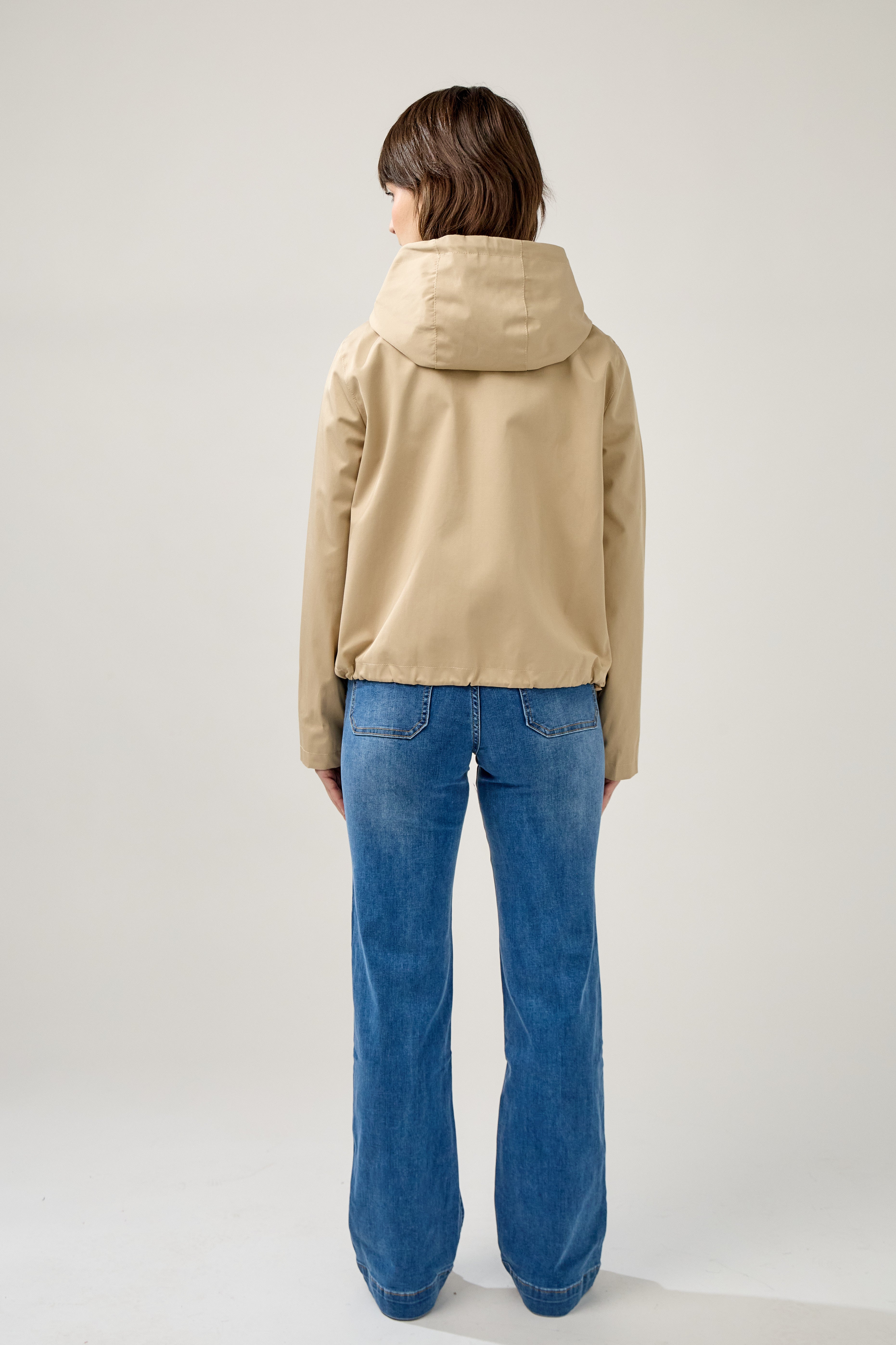 veste coton imperméable à capuche cordons, doublure à carreaux, poches à rabats et bouton pression, fermeture à glissière métallique cachée, bas avec élastique, dos
#couleur_beige