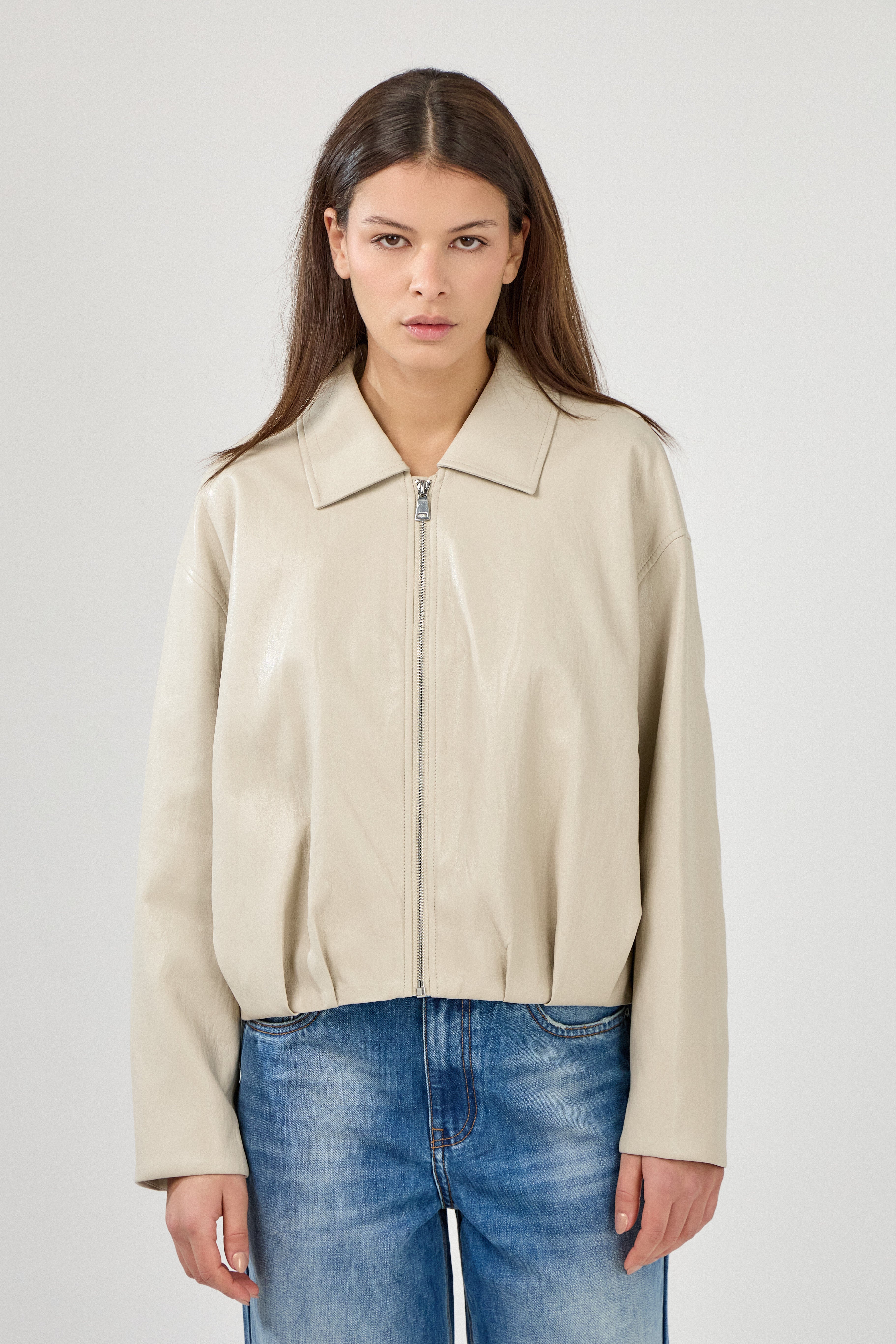 blouson en similicuir à col français, coupe droite, bas plissé devant dos, fermeture à glissière métallique, style streetwear féminin unisexe, devant
#couleur_beige