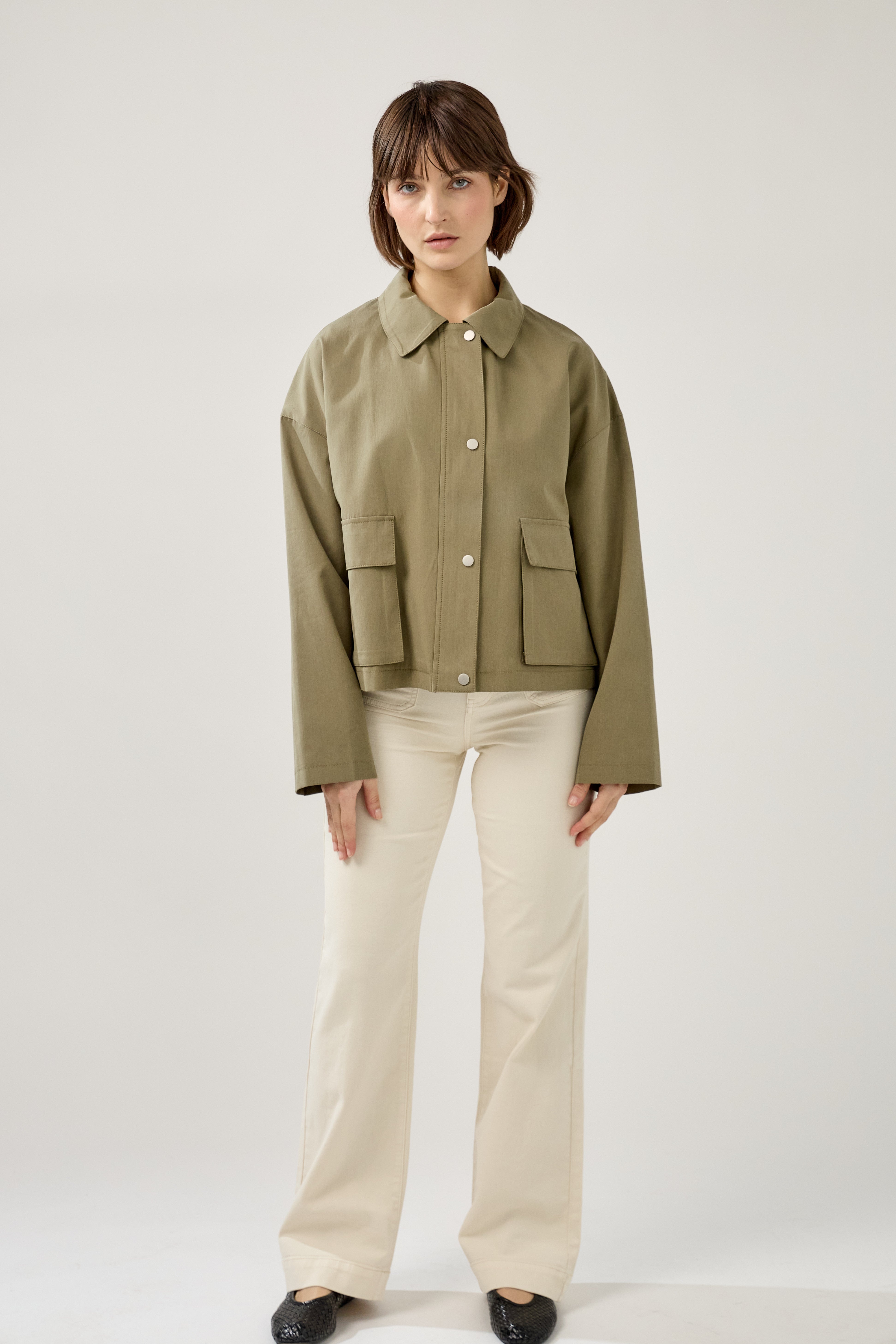 veste en coton kaki clair courte et droite, fermeture à glissière métallique et boutonnière pressions, poches cargos et col français, devant
#couleur_kaki