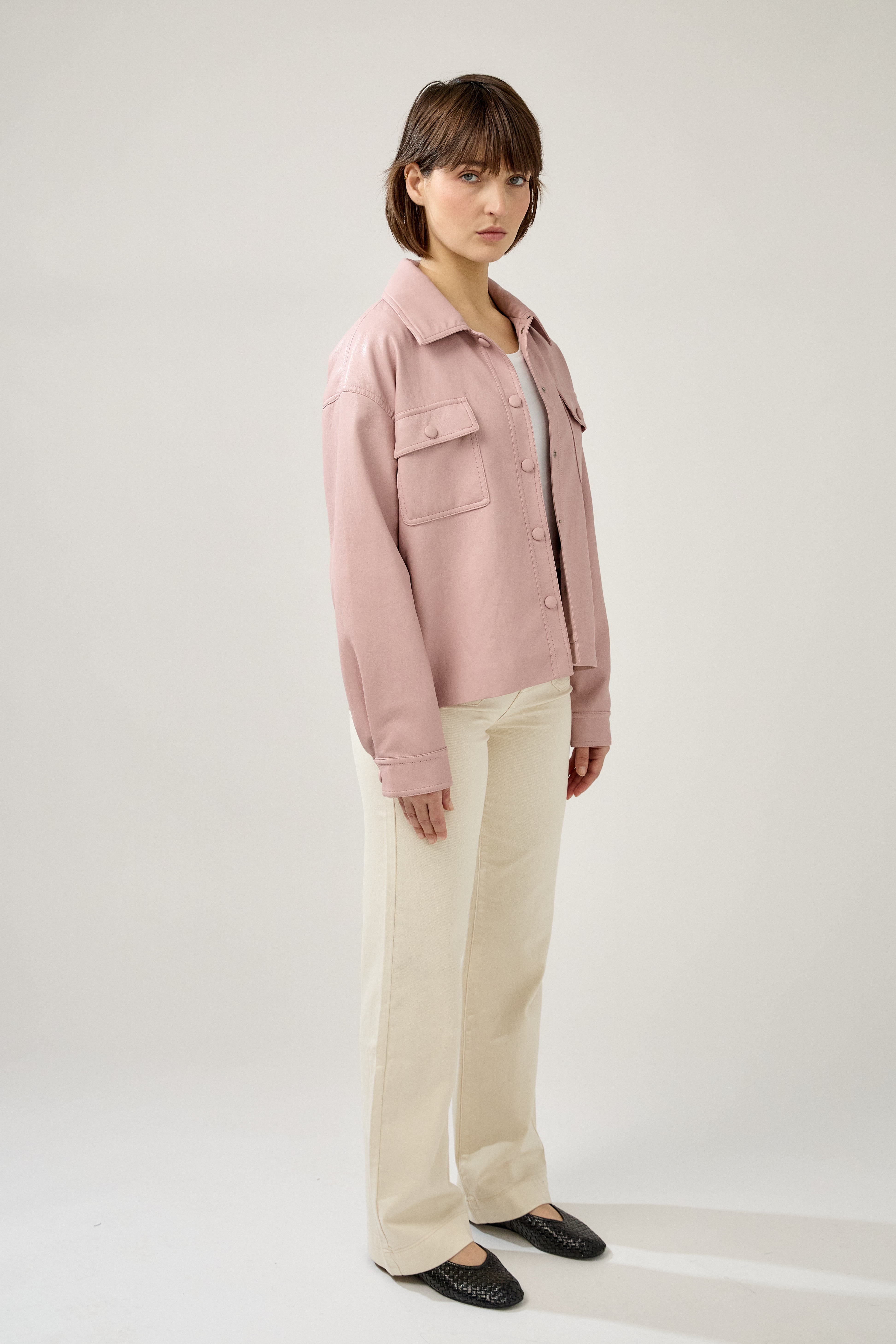 veste en similicuir à ceinture, col français, poches plaquées à rabats boutonnées poitrine, boutonnière avant boutons pressions, côté
#couleur_rose