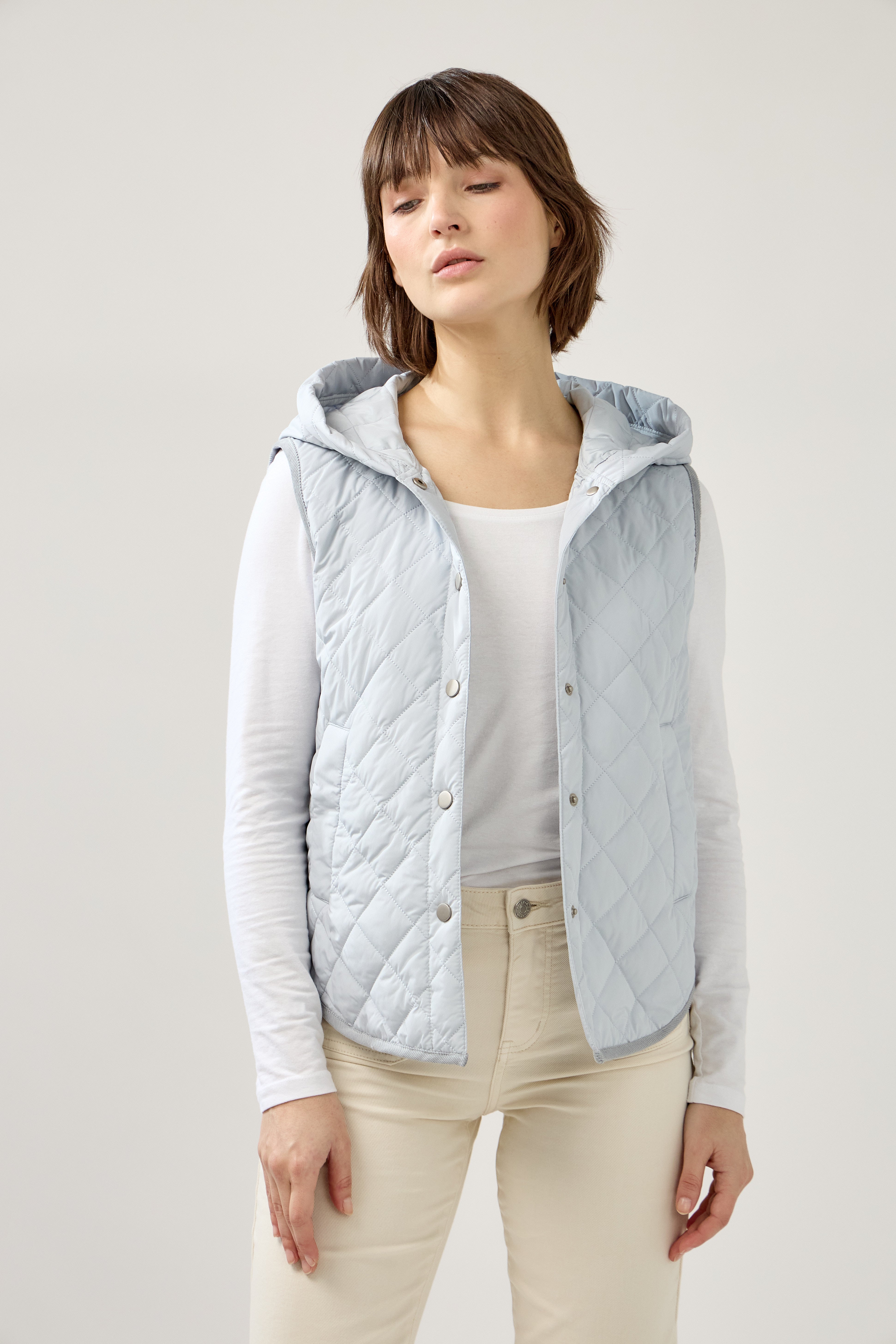 veste matelassée boutonnées, sans manches, capuche, poches raglans, bas arrondi, devant
#couleur_bleu