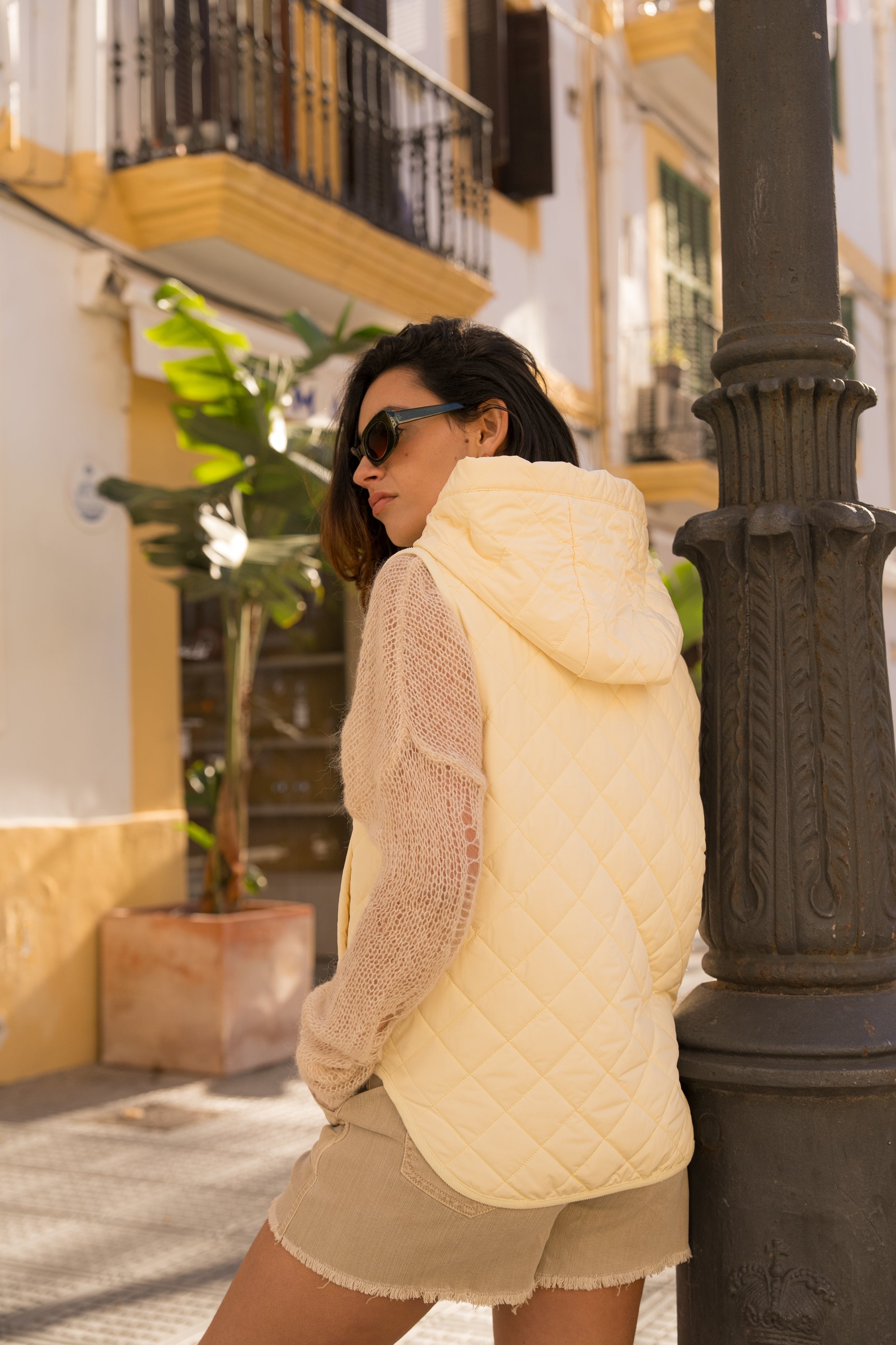 veste matelassée boutonnées, sans manches, capuche, poches raglans, bas arrondi, dos
#couleur_jaune