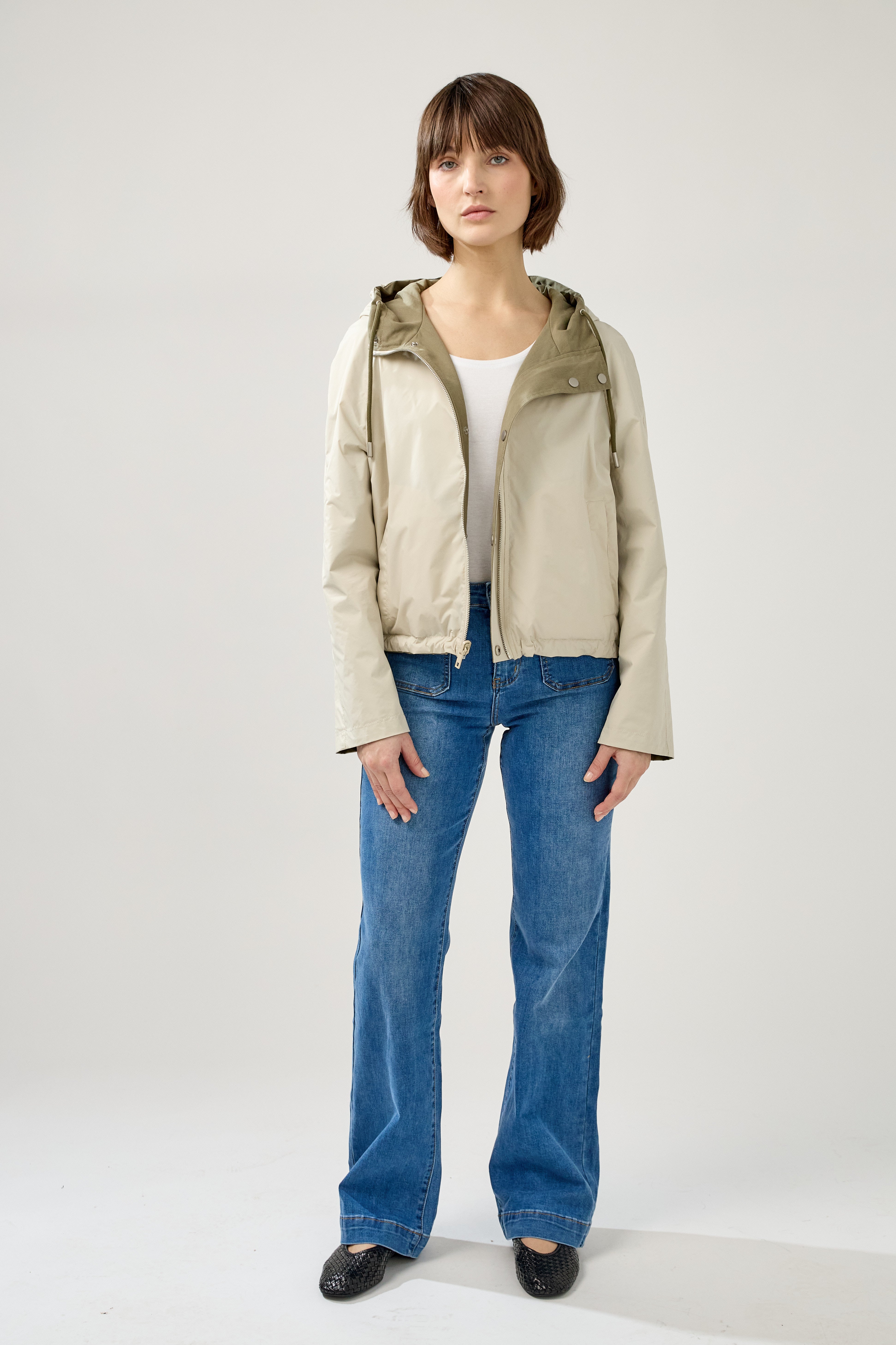 femme portant la parka Elunia réversible kaki clair/beige, fermeture à glissière et boutons à pressions, capuche à cordon, poche à rabats, bas ajustable, devant beige réversible
#couleur_kaki