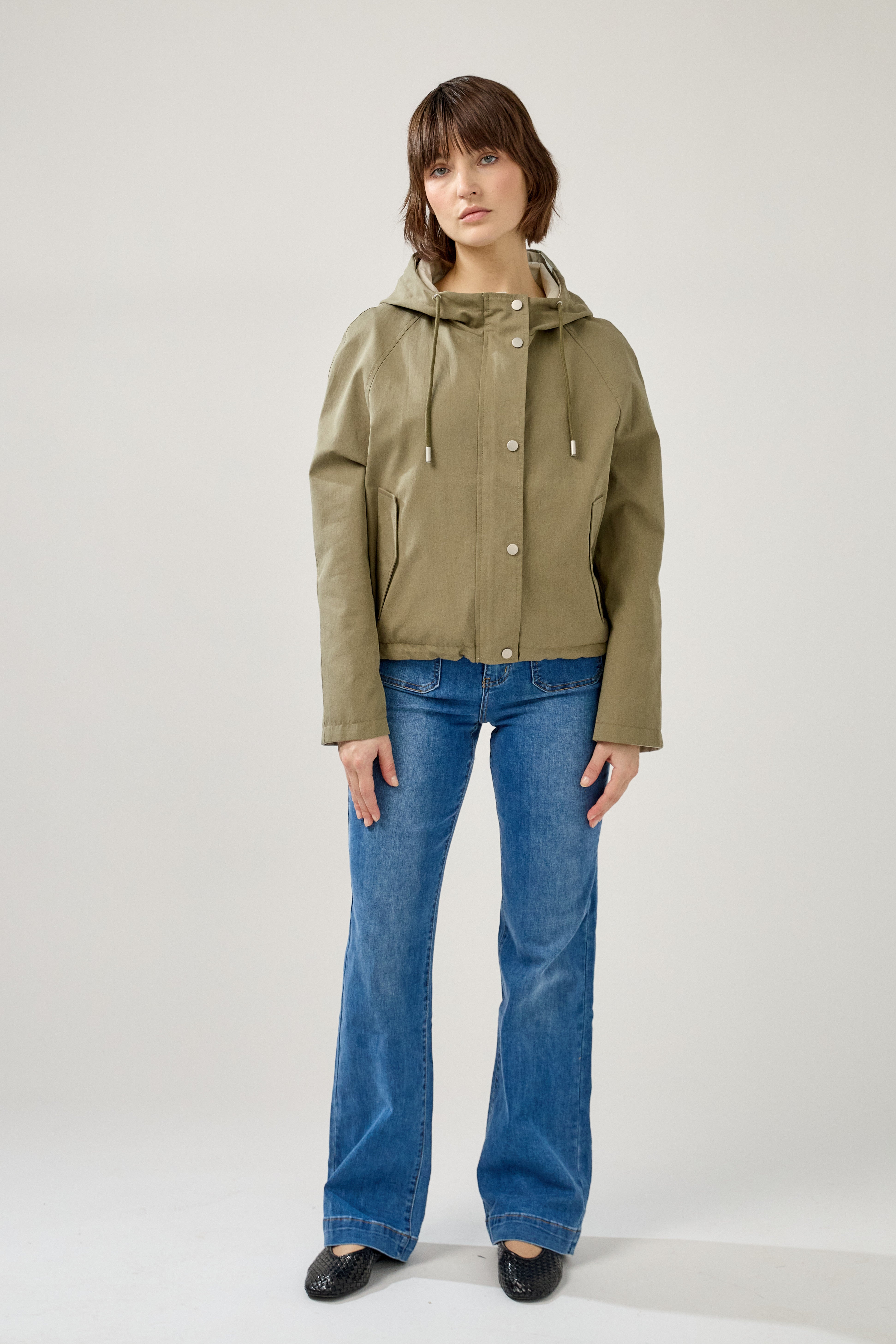 femme portant la parka Elunia réversible kaki clair/beige, fermeture à glissière et boutons à pressions, capuche à cordon, poche à rabats, bas ajustable, devant
#couleur_kaki