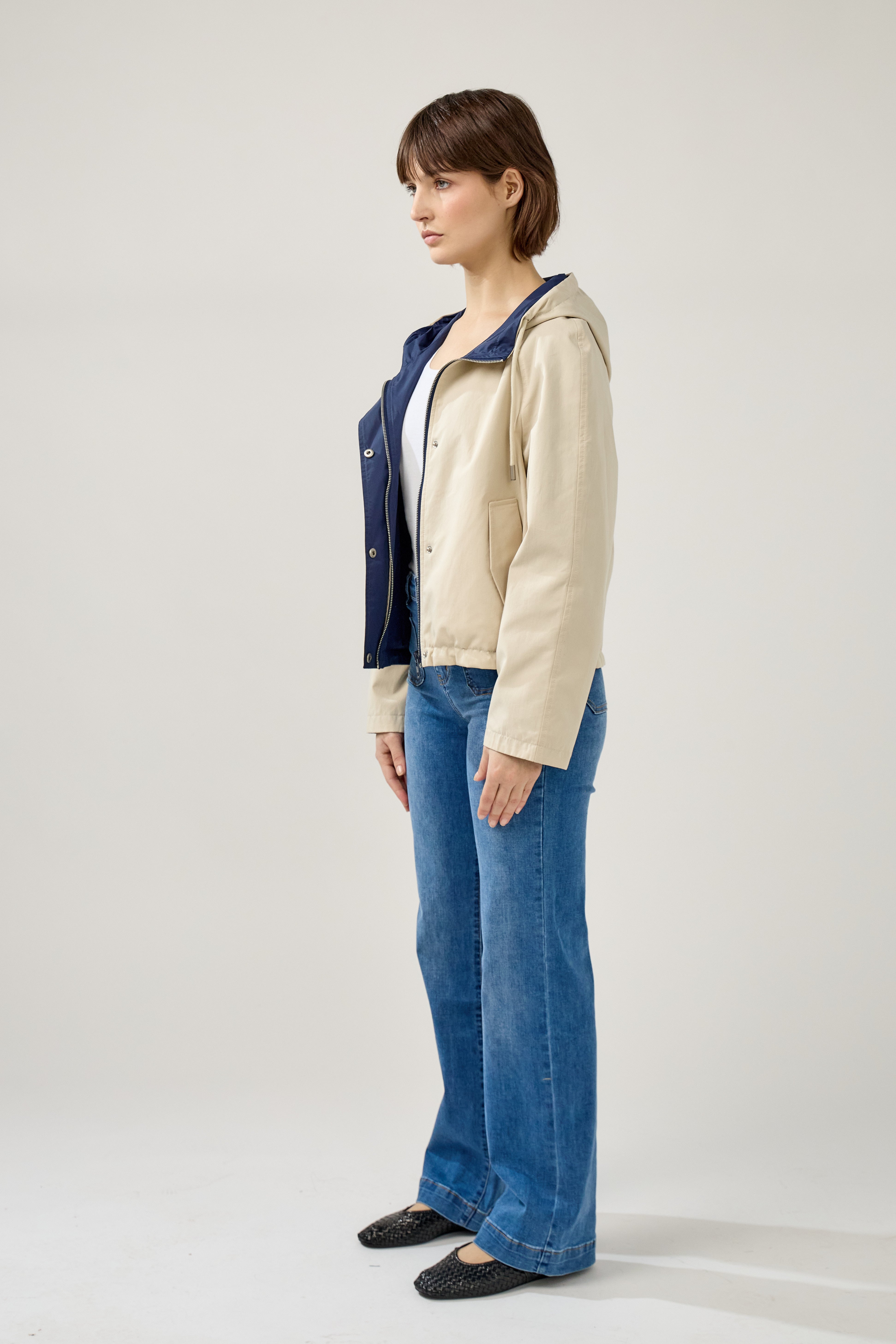 femme portant la parka Elunia réversible beige/marine, fermeture à glissière et boutons à pressions, capuche à cordon, poche à rabats, bas ajustable, côté
#couleur_beige