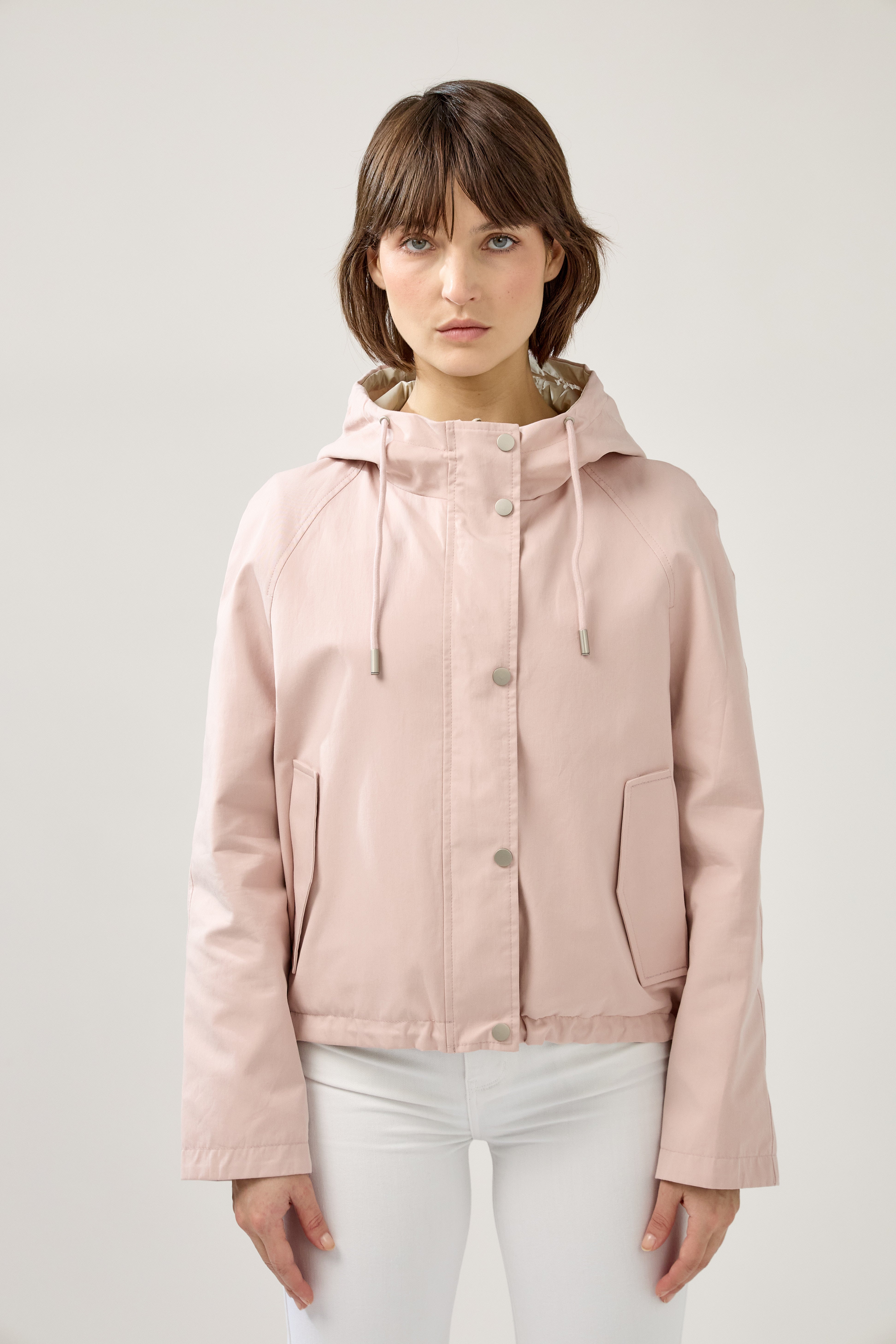 femme portant la parka Elunia réversible rose pâle/beige, fermeture à glissière et boutons à pressions, capuche à cordon, poche à rabats, bas ajustable, zoom devant
#couleur_rose