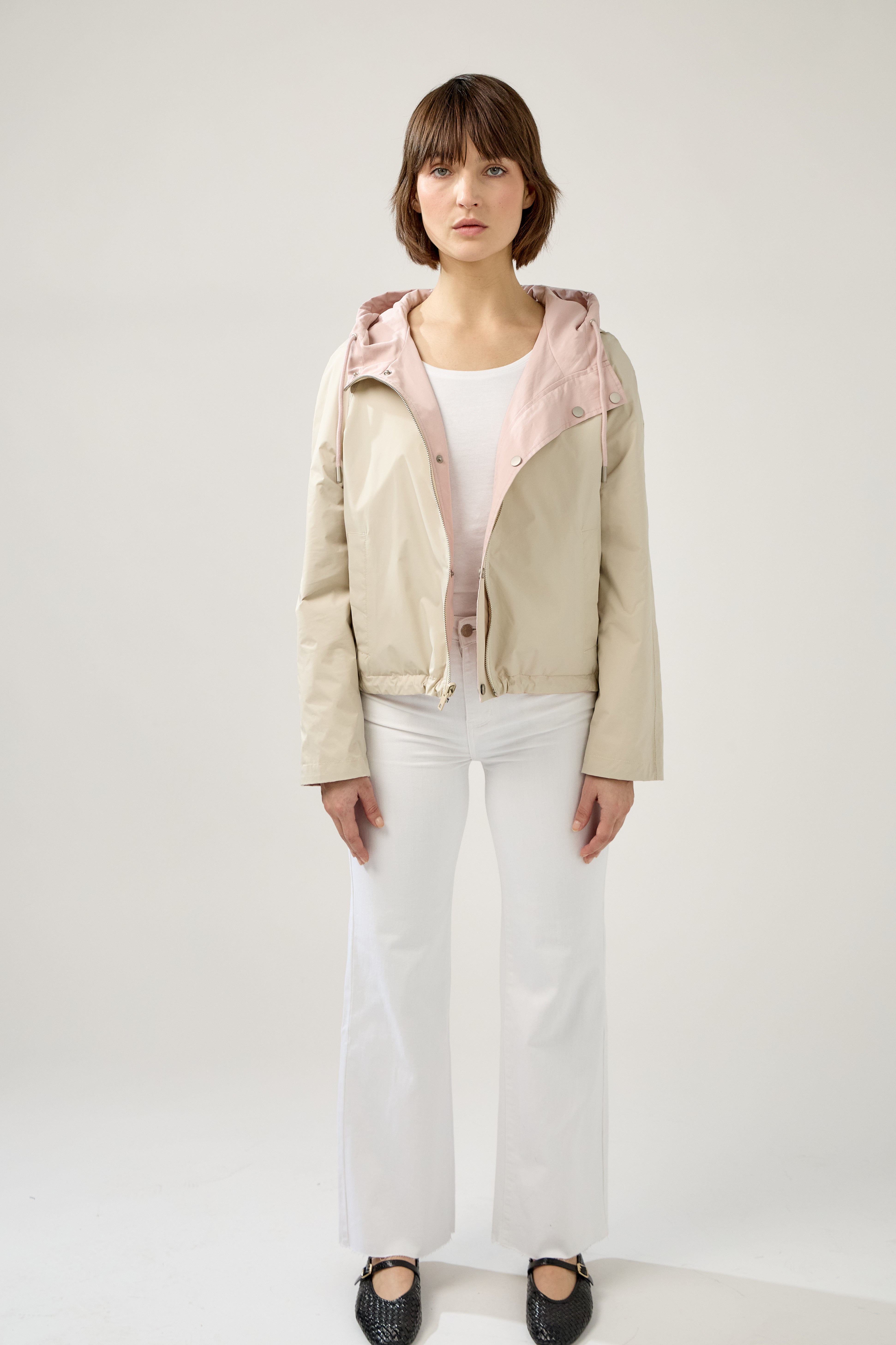 femme portant la parka Elunia réversible rose pâle/beige, fermeture à glissière et boutons à pressions, capuche à cordon, poche à rabats, bas ajustable, devant beige réversible
#couleur_rose
